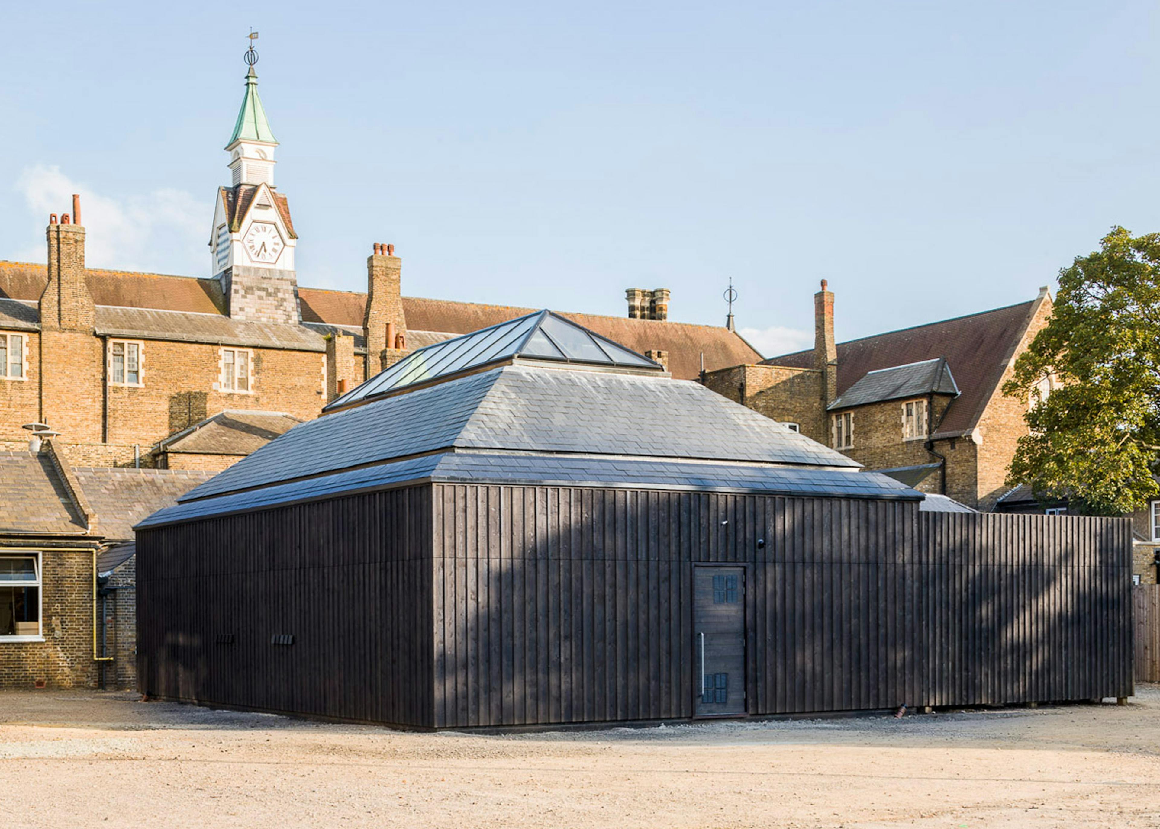 A timber clad Douglas fir framed school building with old school buildings behind