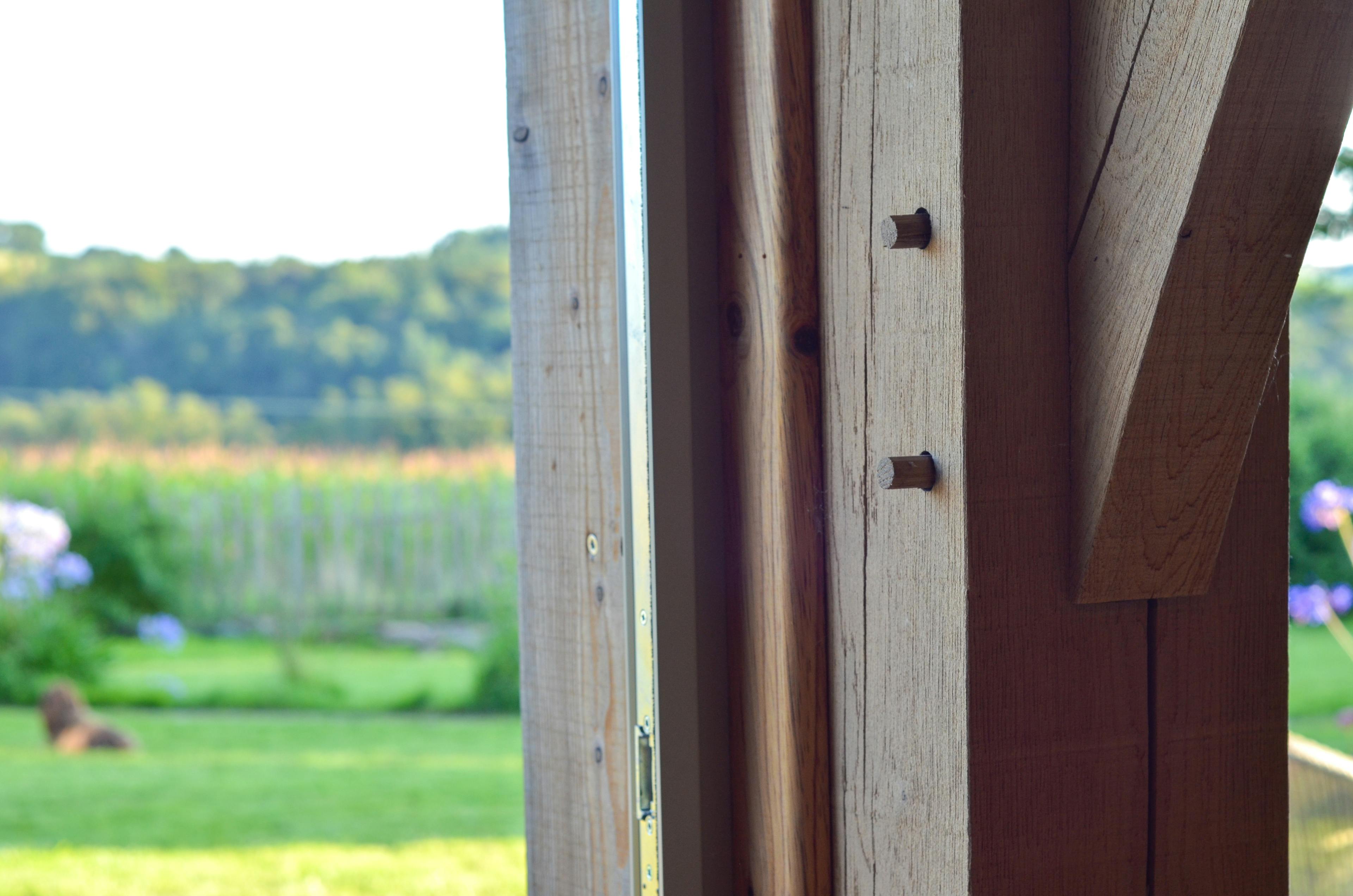 The oak post of a 2-bay oak framed extension with views of the green surrounding countryside 