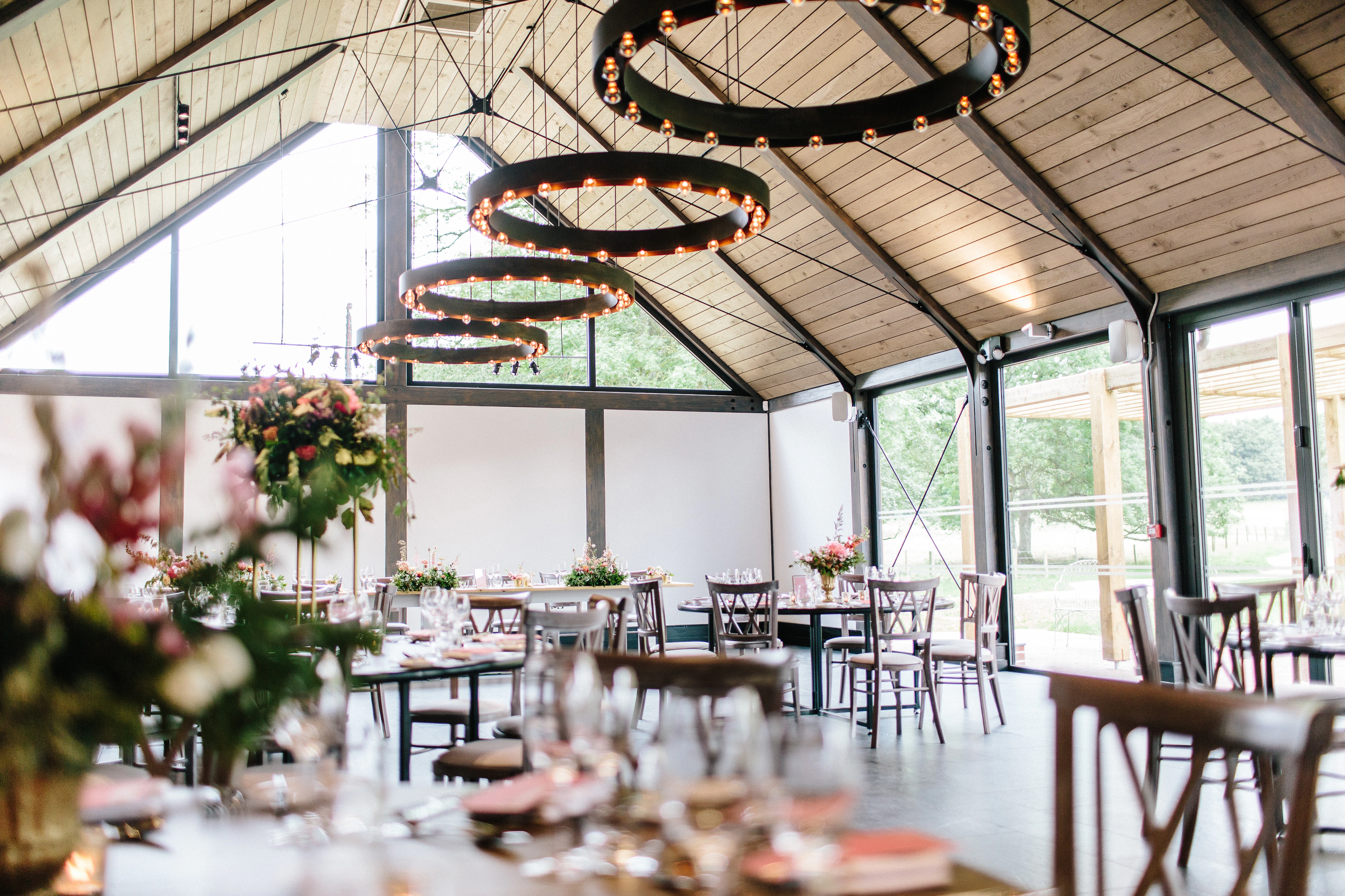 Tables laid and ready for guests in a timber white spruce glulam wedding barn