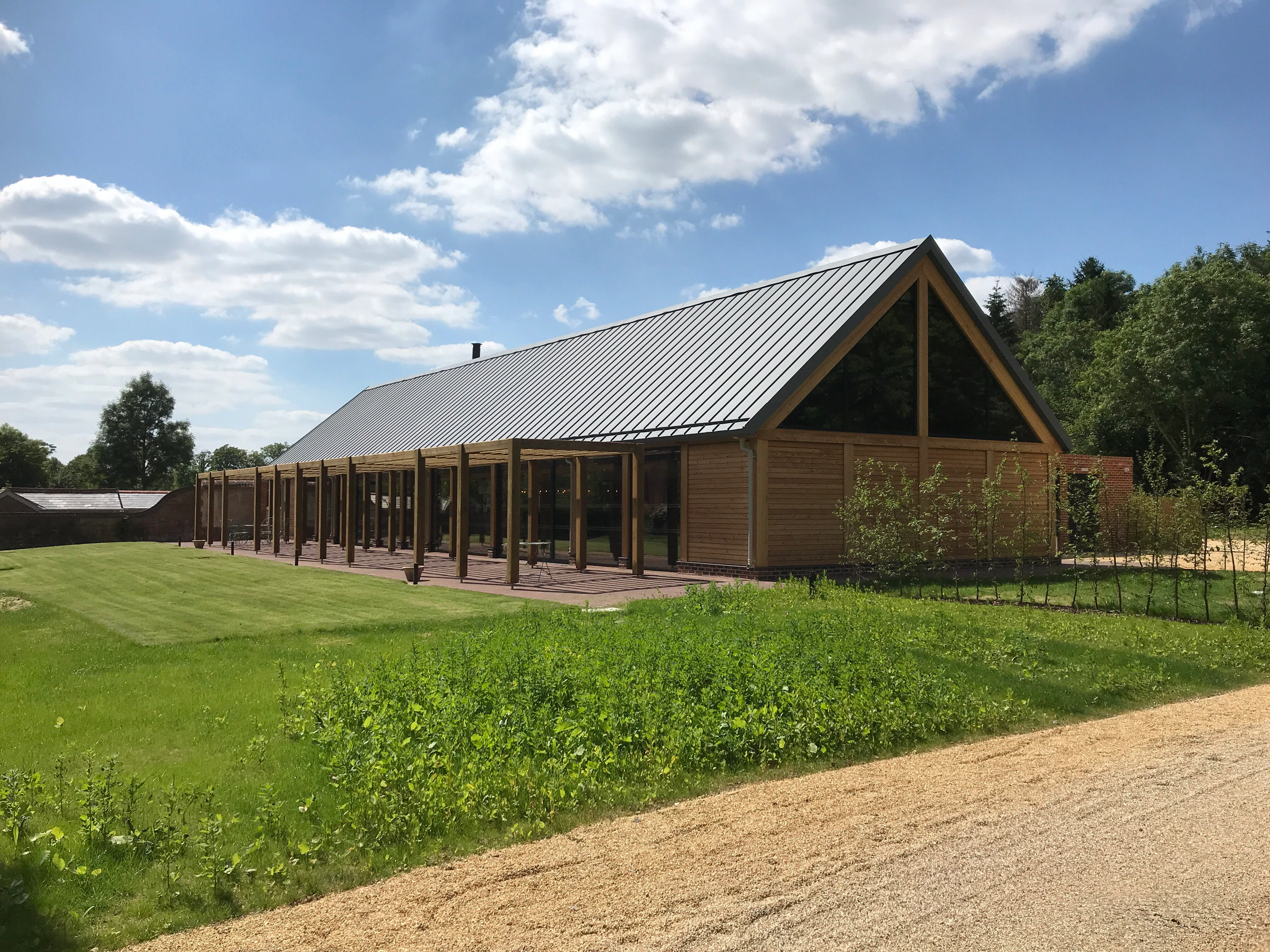 A timber white spruce glulam wedding barn next to a green lawn