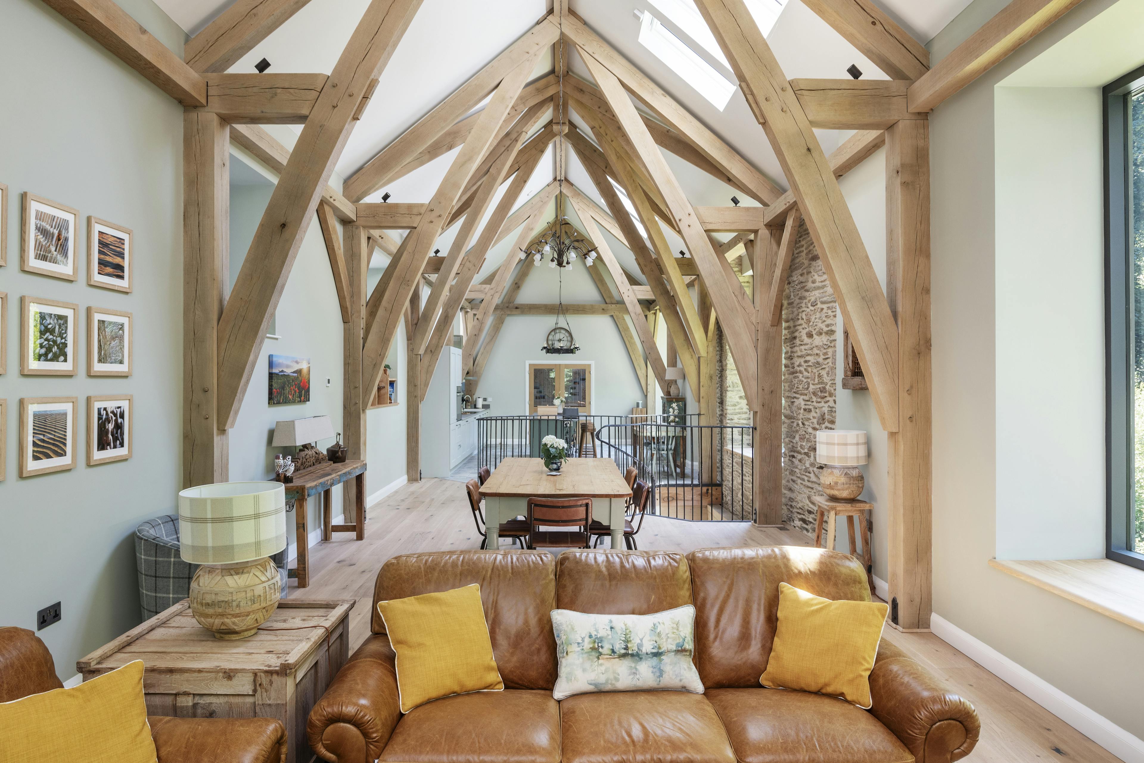 Vaulted oak framed ceiling with sofa and dining area