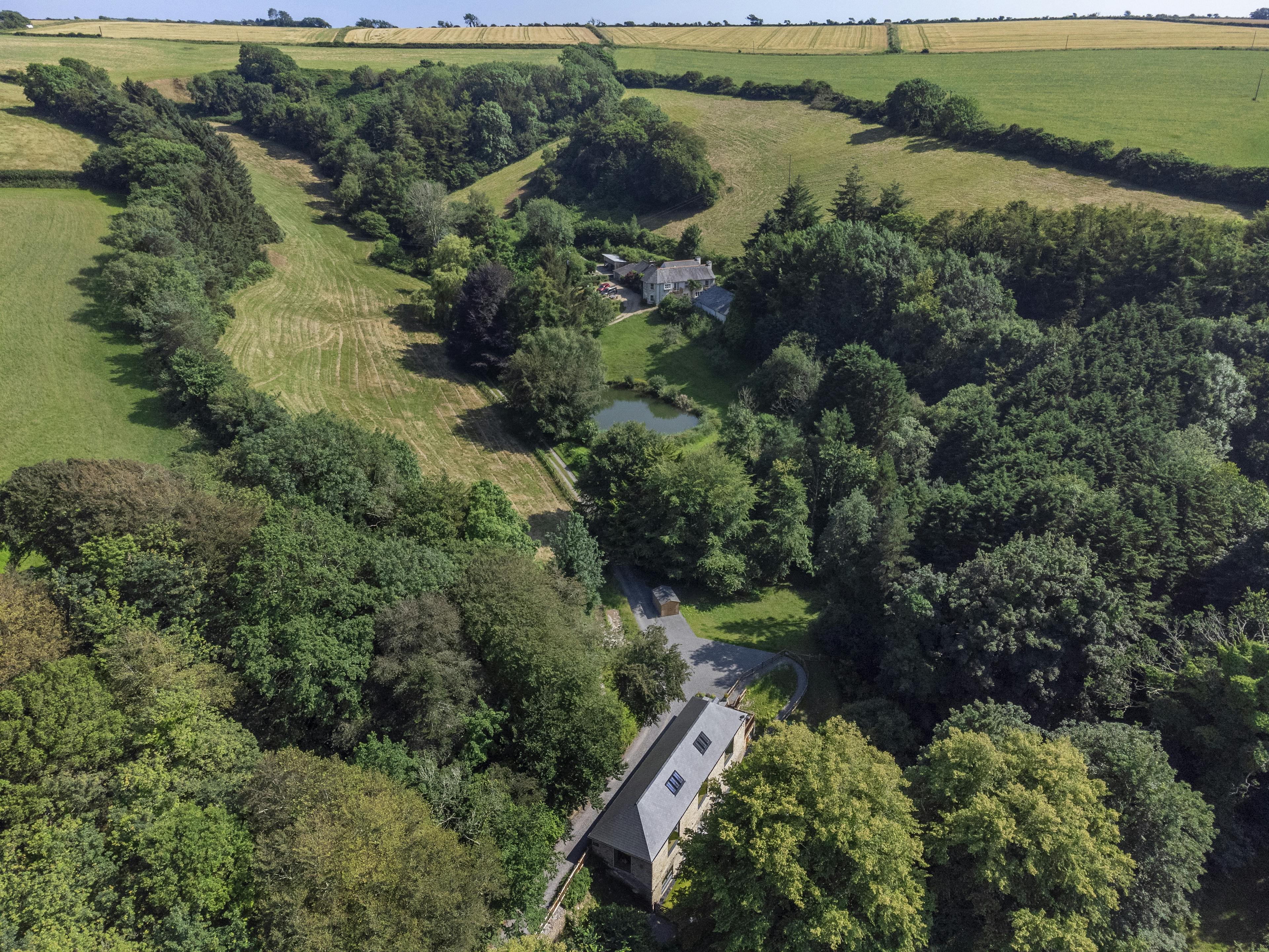 Aerial view of a renovated stone barn surrounded by picturesque countryside