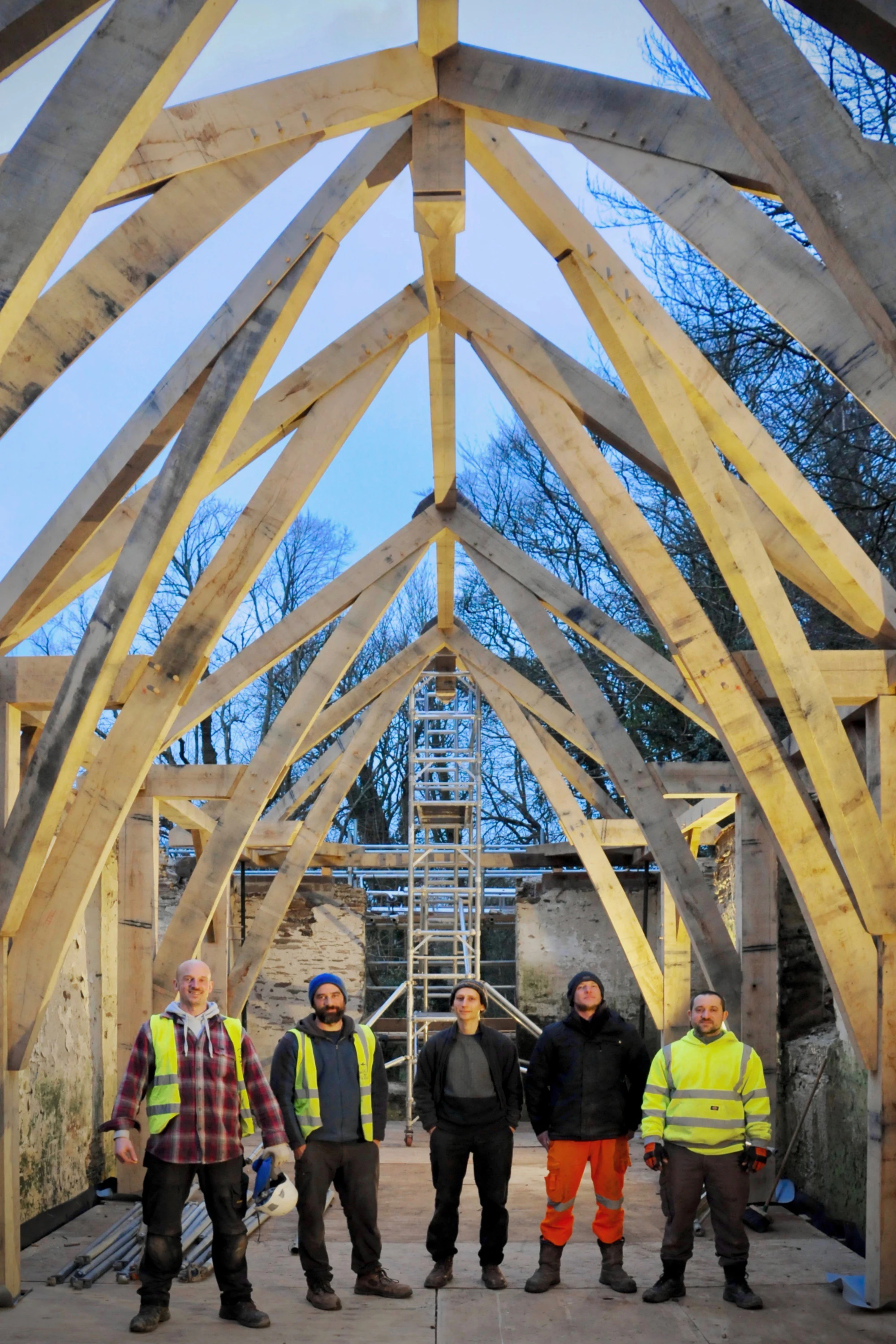 The site team responsible for installing a structural oak frame inside a stone barn