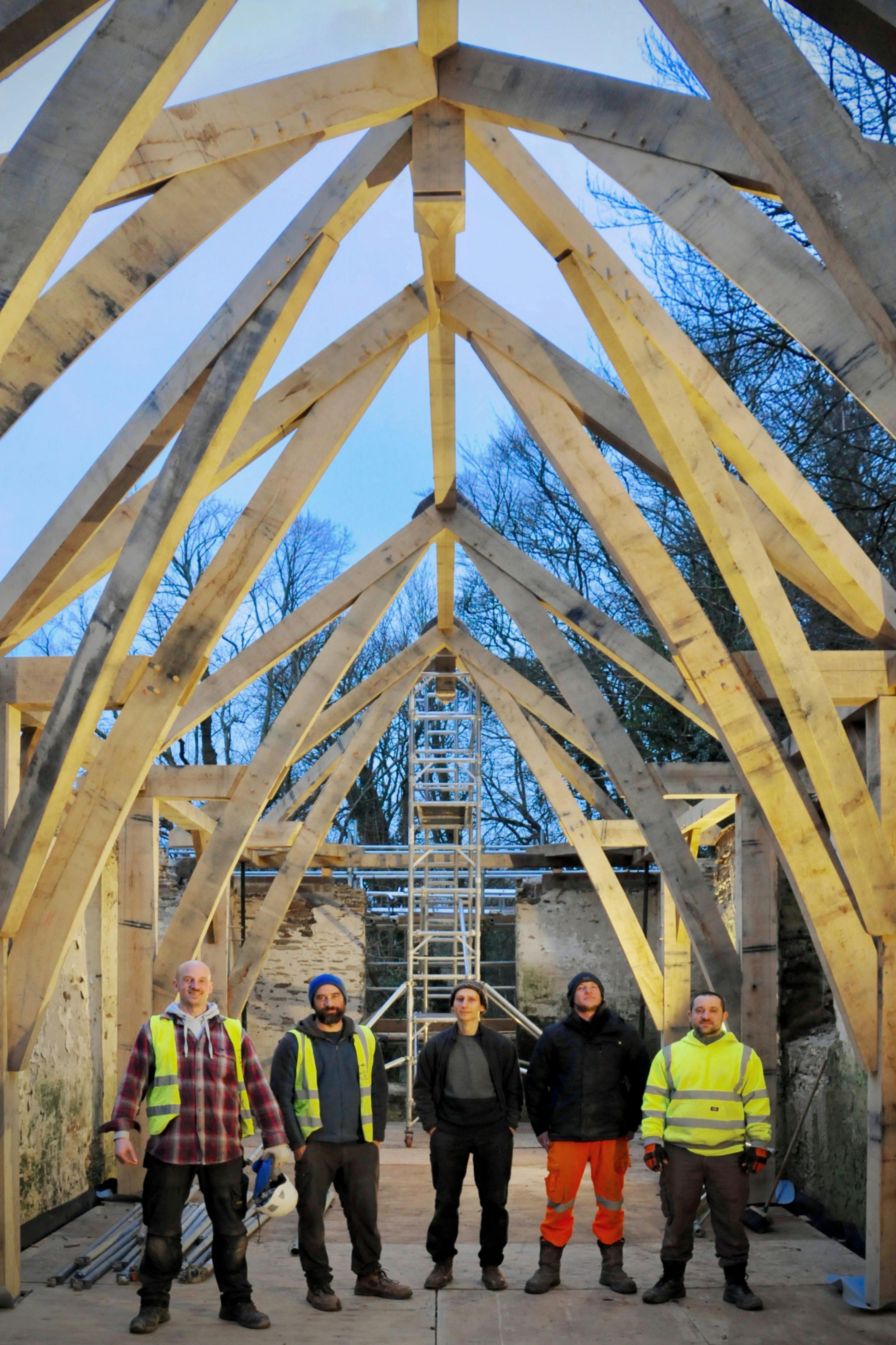 The site team responsible for installing a structural oak frame inside a stone barn