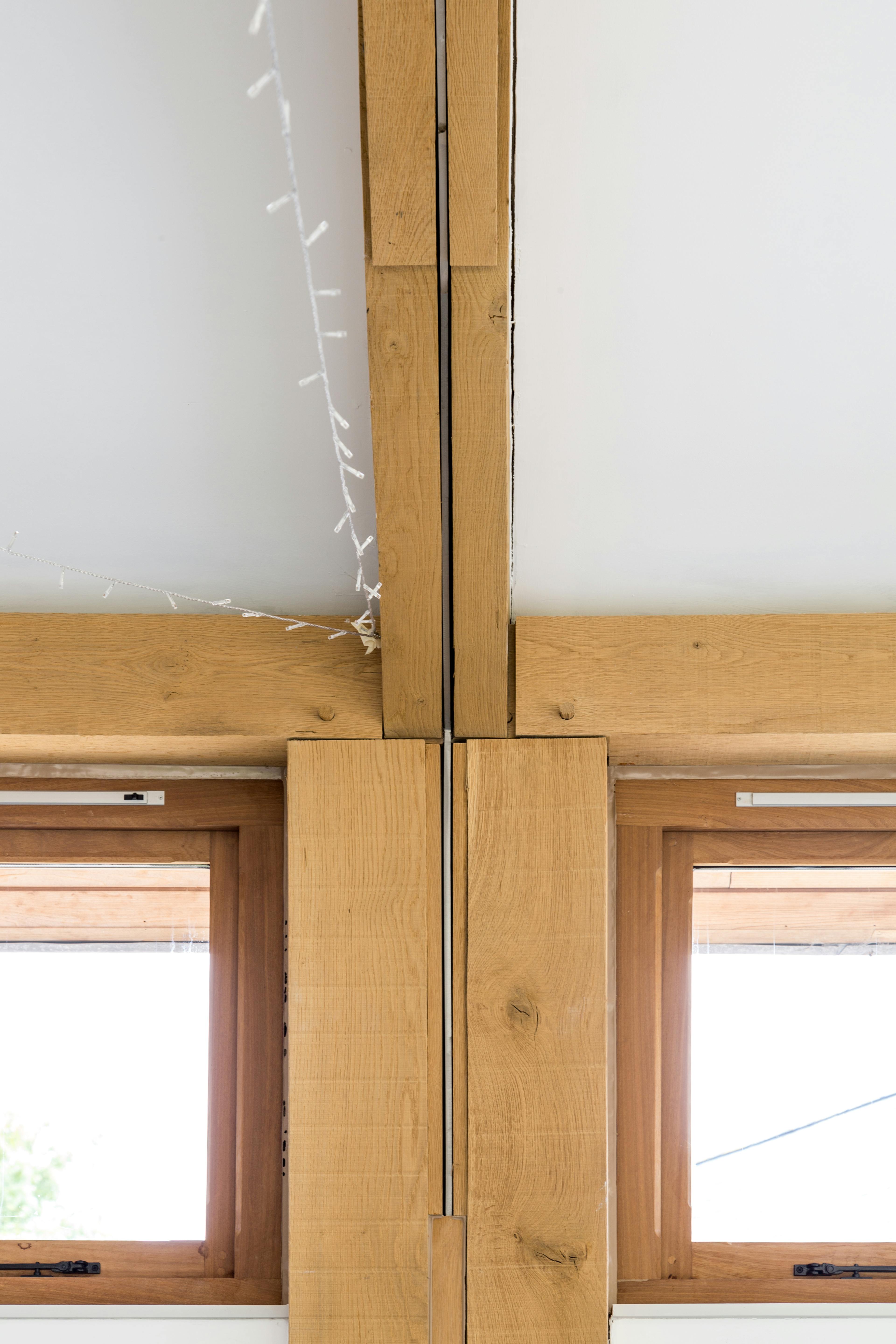 Close-up view of a steel flitch plate integrated into a structural oak frame