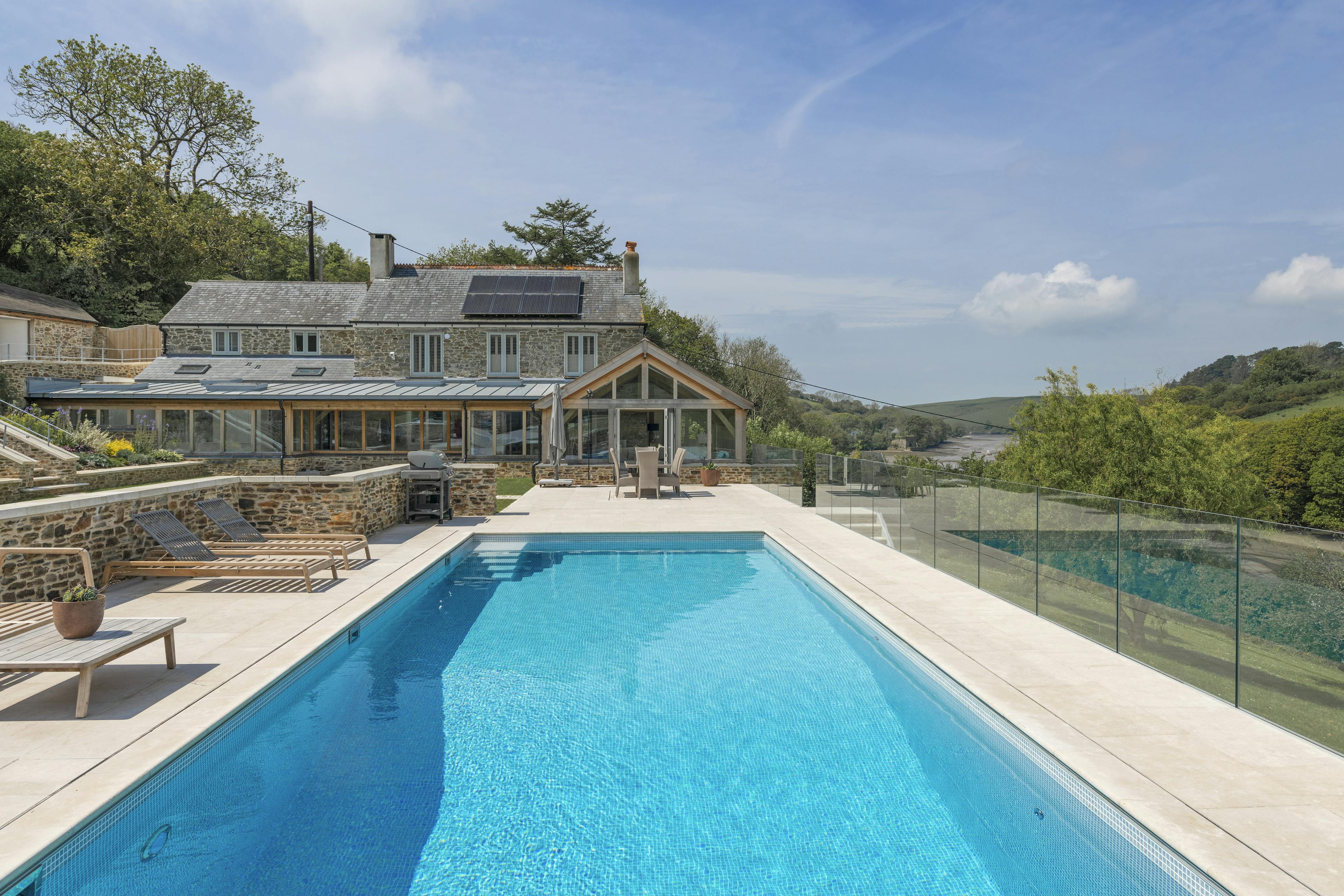 A renovated cottage on an estuary with a a swimming pool, green lawn and oak framed garden room, entrance and corridor extension