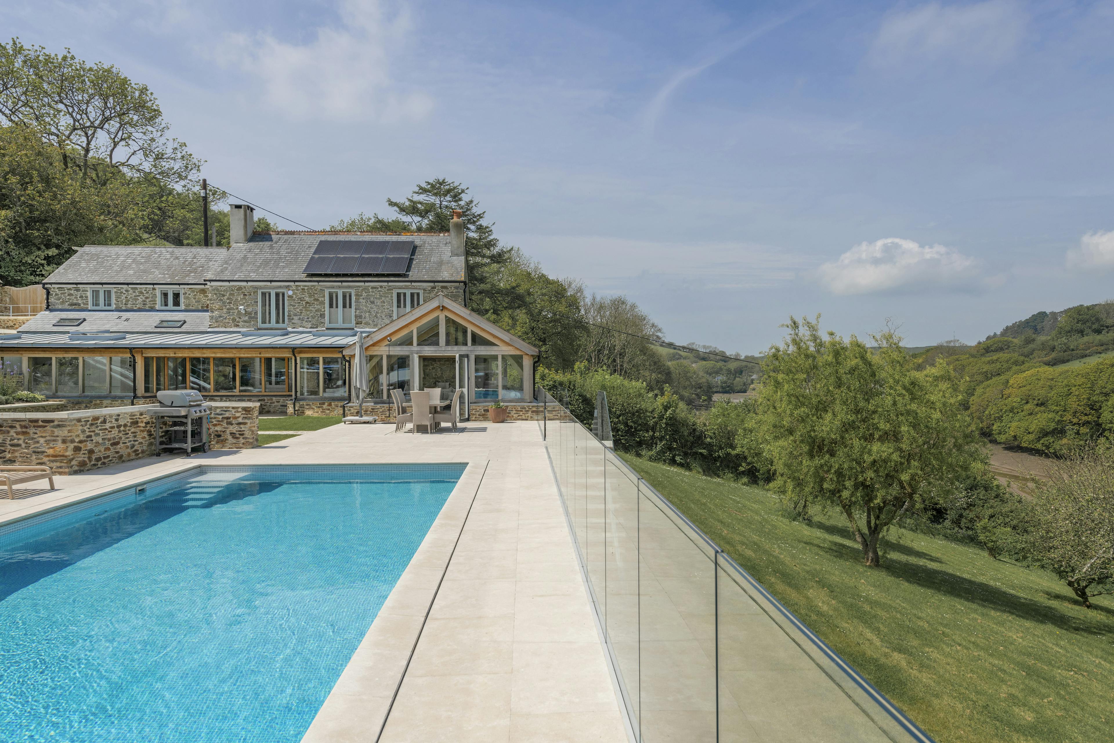 A renovated cottage on an estuary with a a swimming pool, green lawn and oak framed garden room, entrance and corridor extension