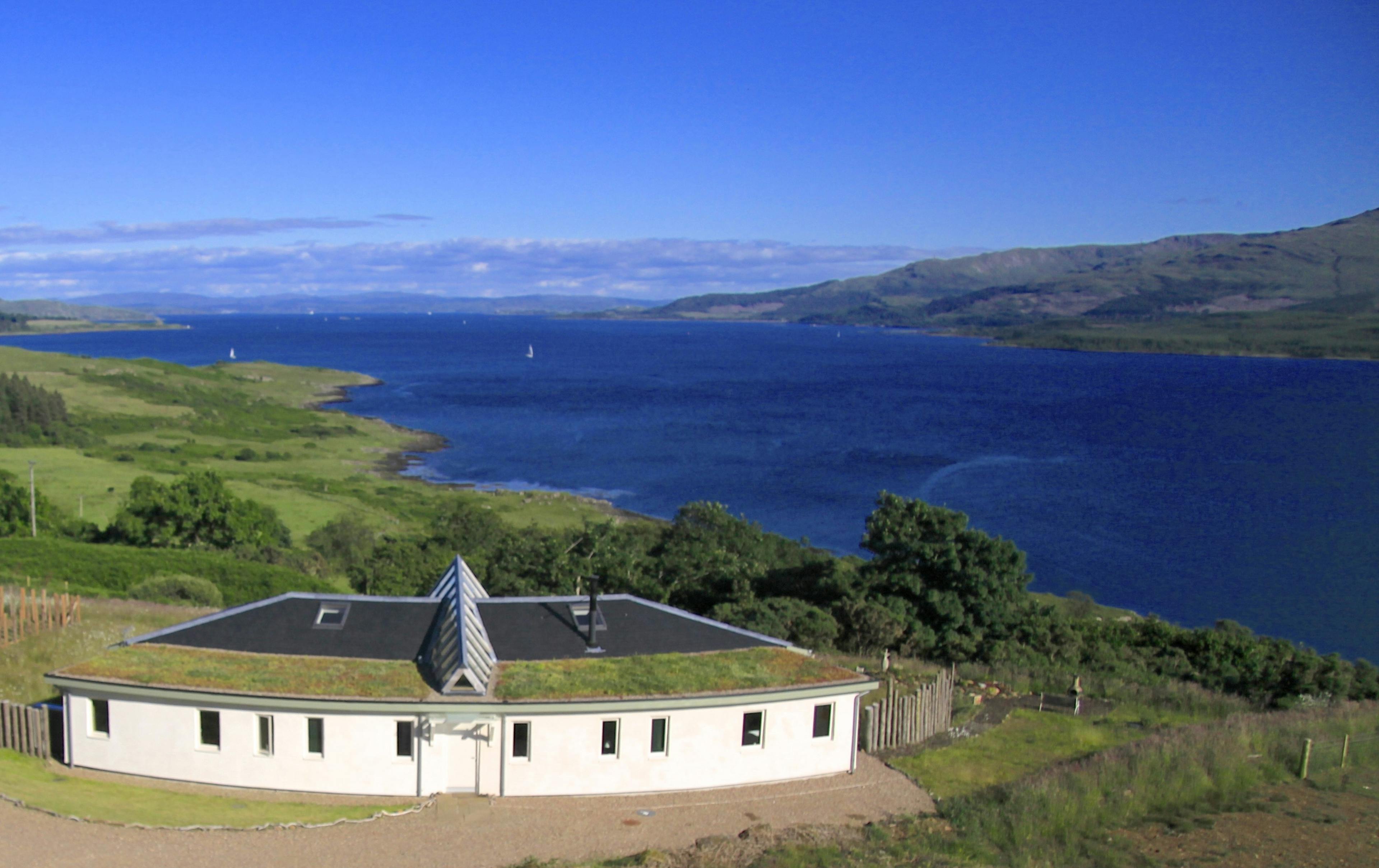 A curved oak framed house by a loch in Scotland