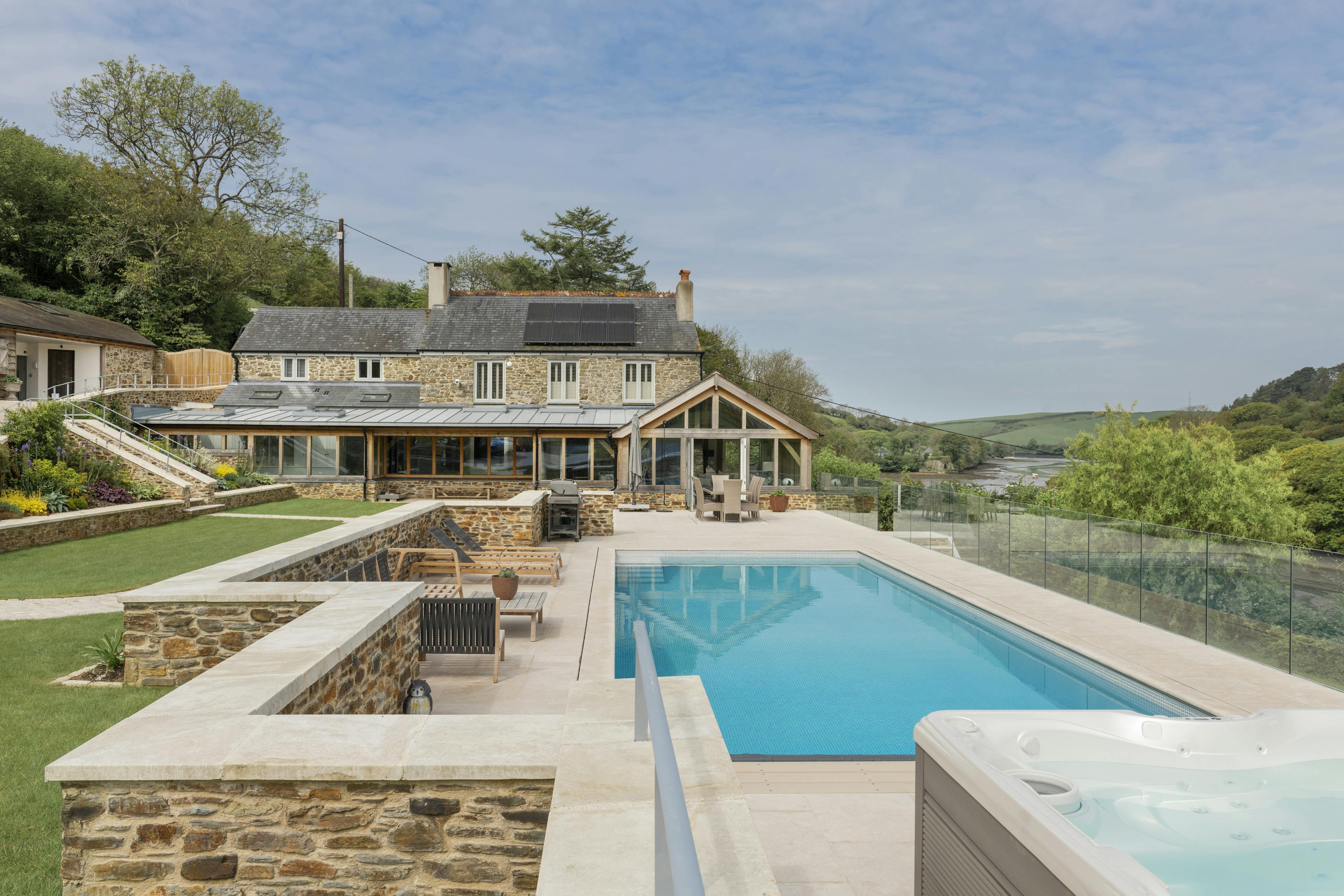 A renovated cottage on an estuary with a a swimming pool, green lawn and oak framed garden room, entrance and corridor extension