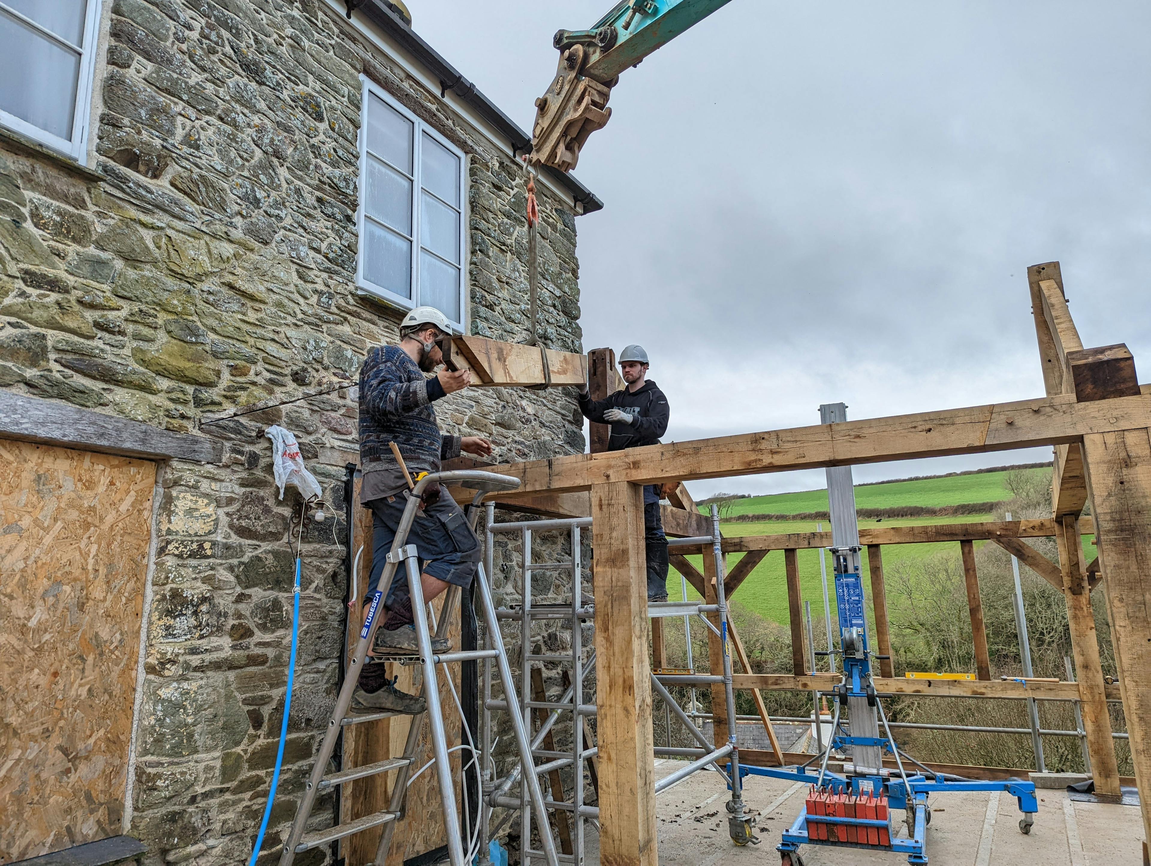 Carpenters raising the frame for an oak framed garden room, entrance and corridor extension during installation
