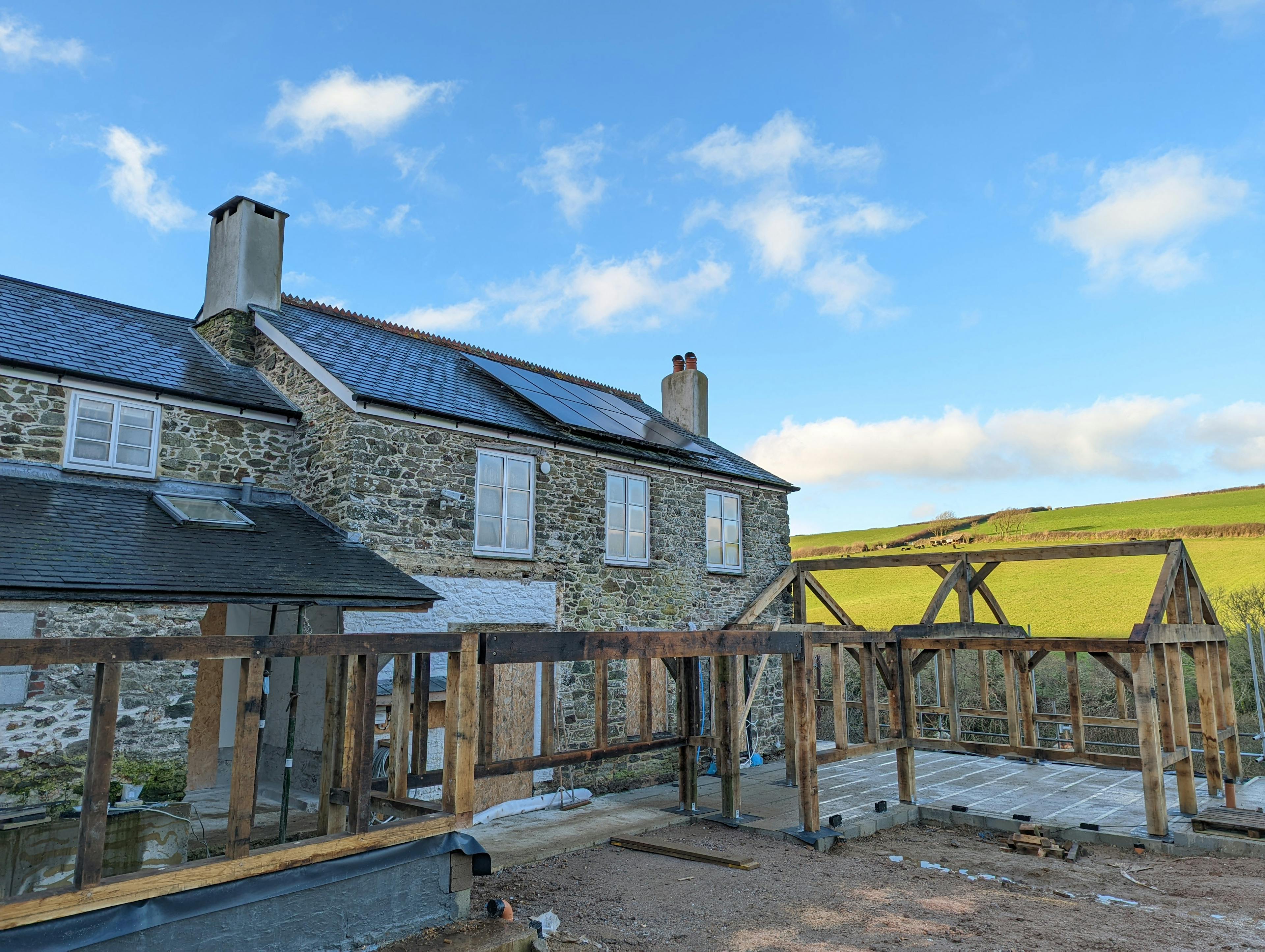The frame for an oak framed garden room, entrance and corridor extension during installation 