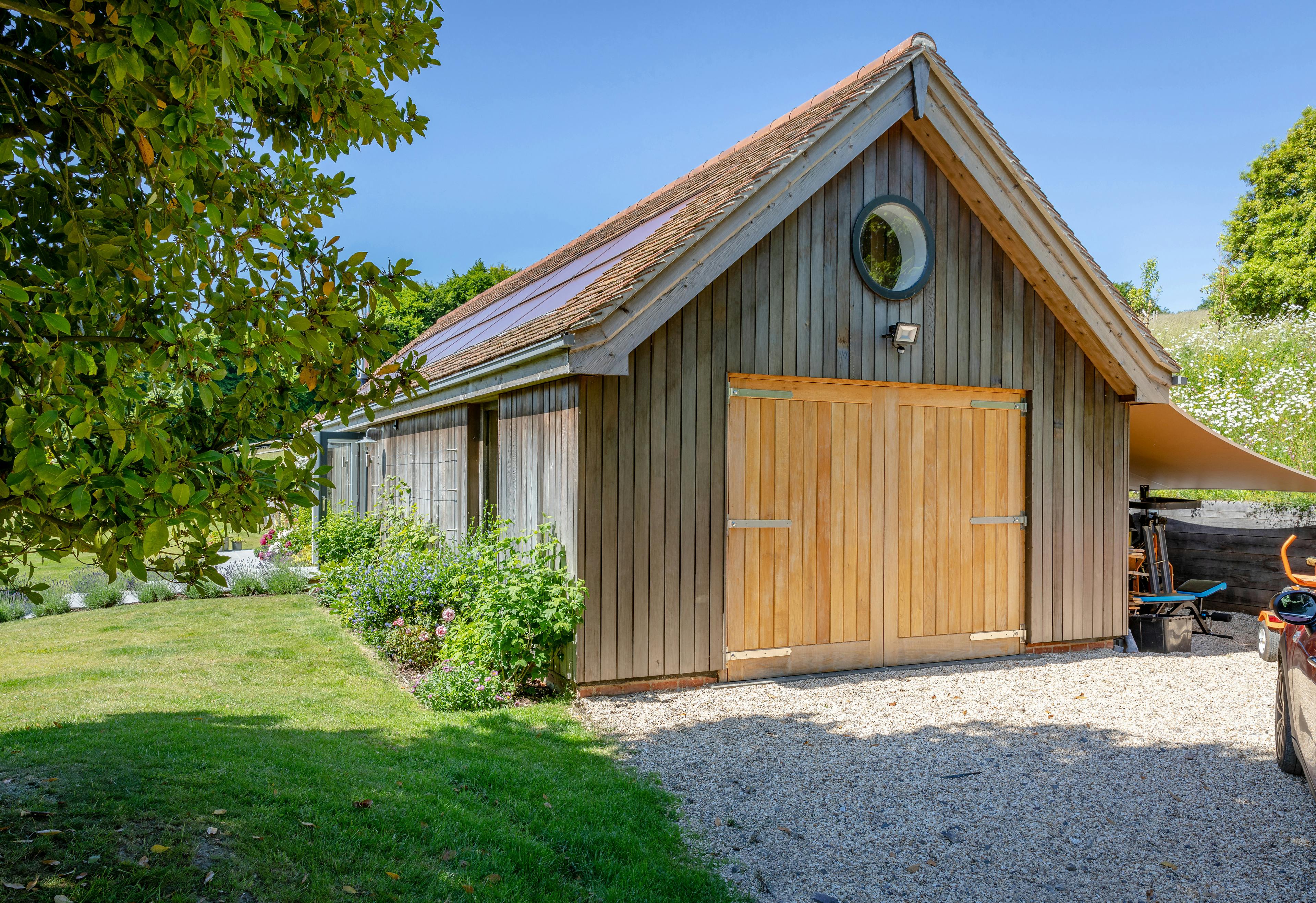The rear of an oak framed garden annex surrounded by a landscaped garden
