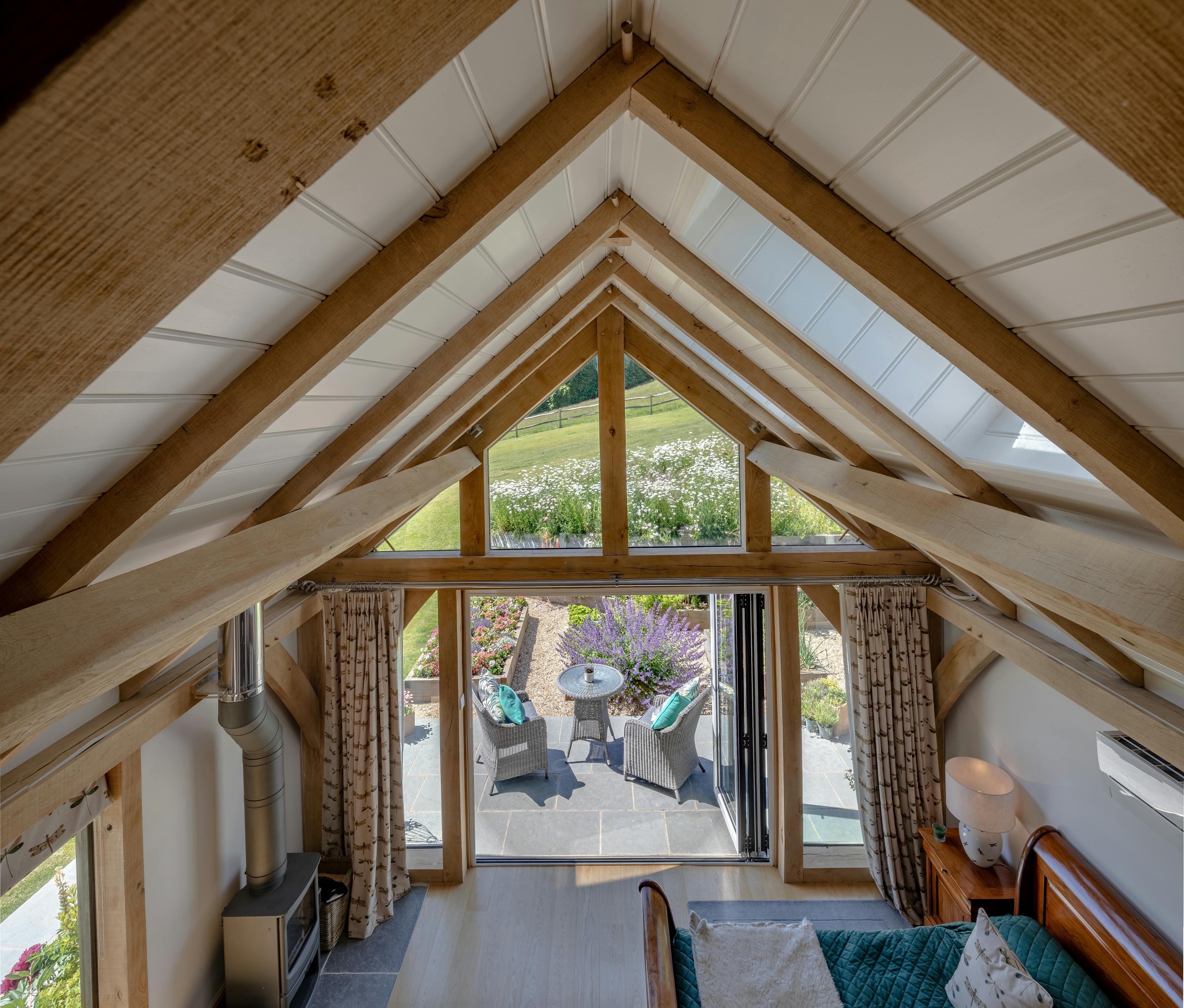 The ceiling inside an oak framed garden annex with white painted roof boarding