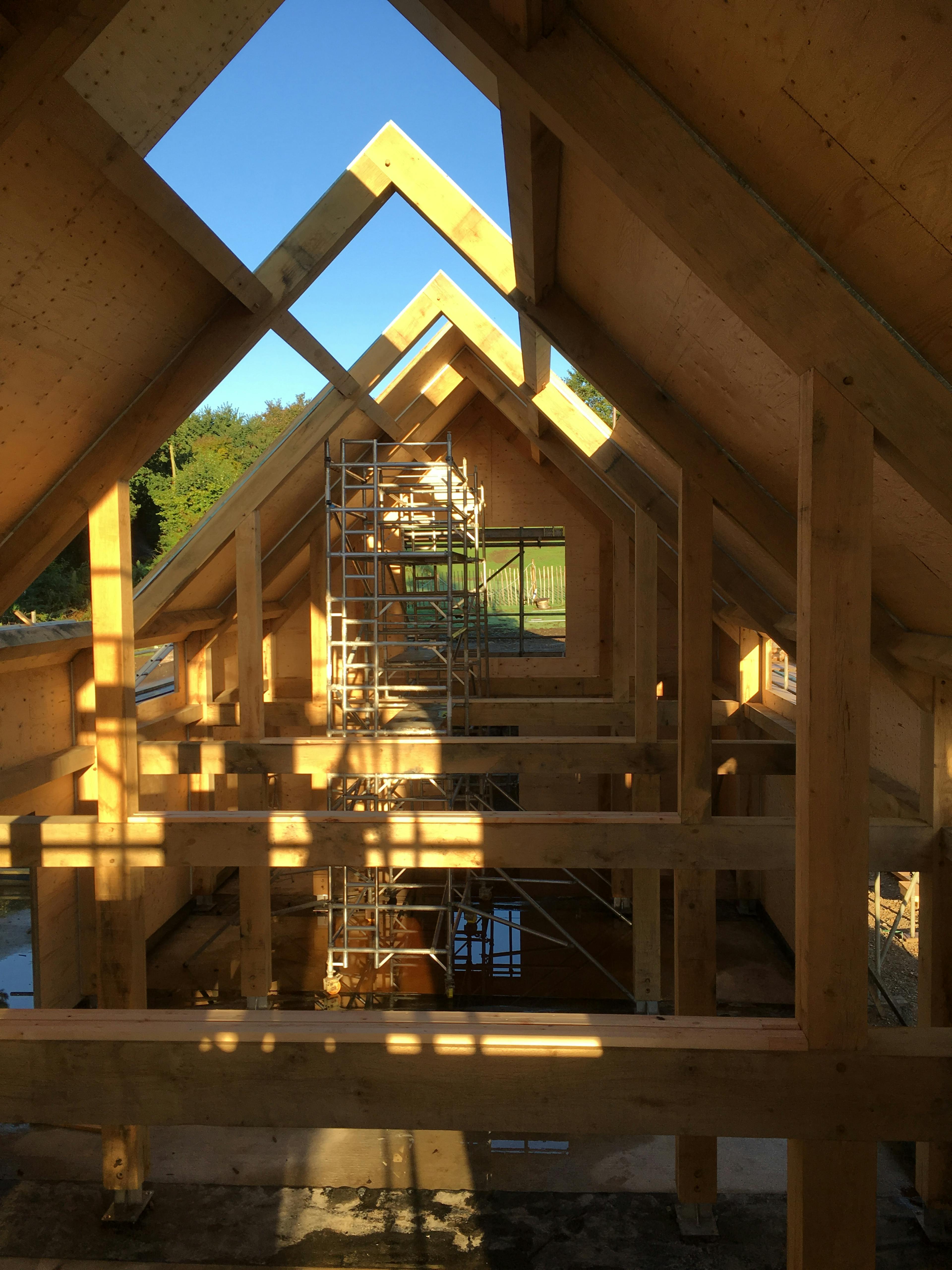 Interior view of a structural oak frame being boarded with solid timber panels on-site