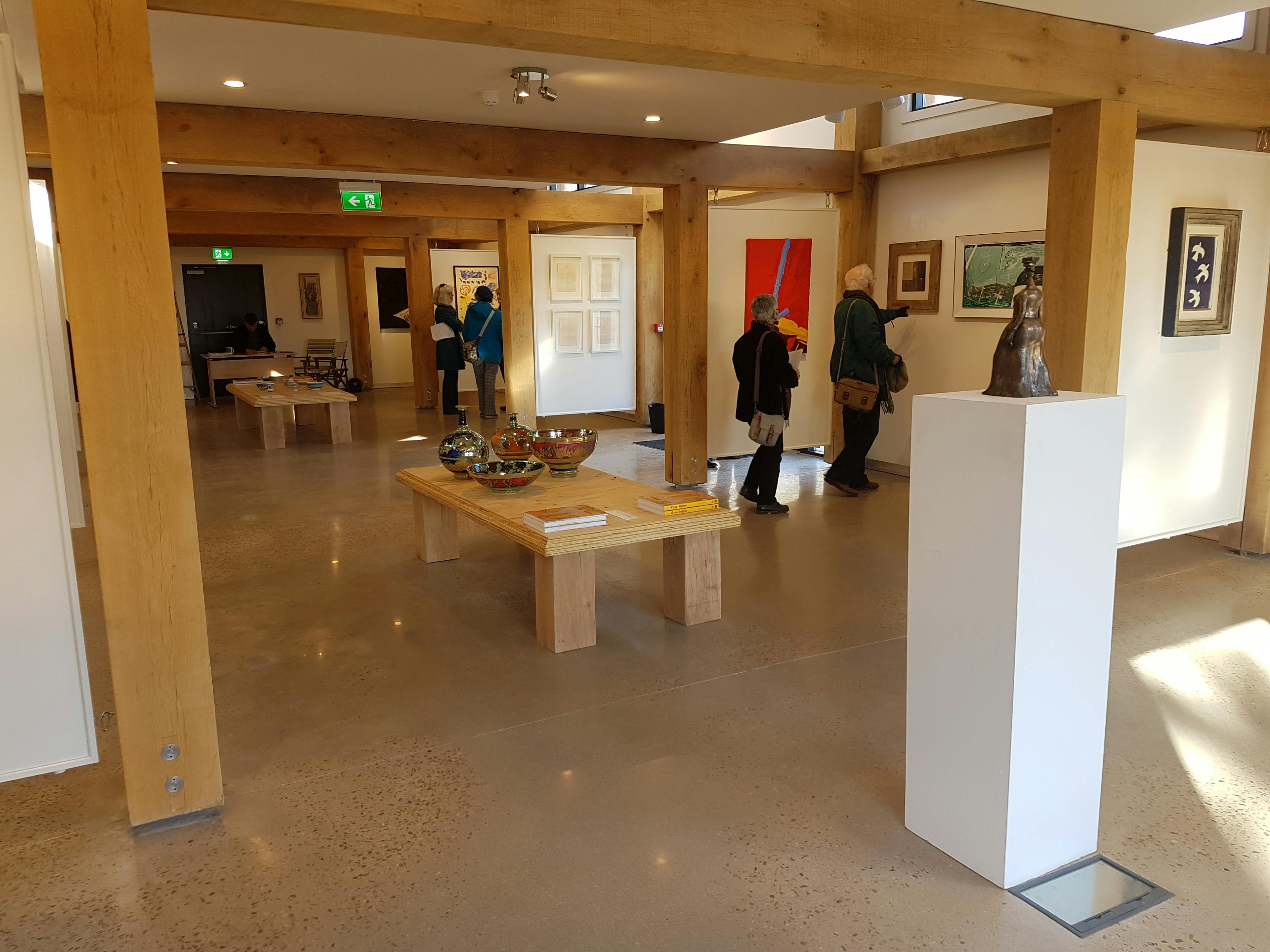Interior view of a contemporary art gallery space with a structural oak frame