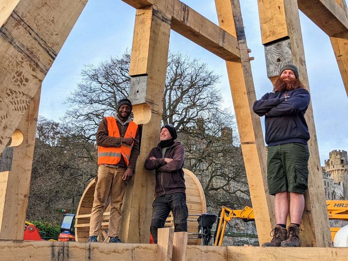 Three carpenters on an timber framed trebuchet
