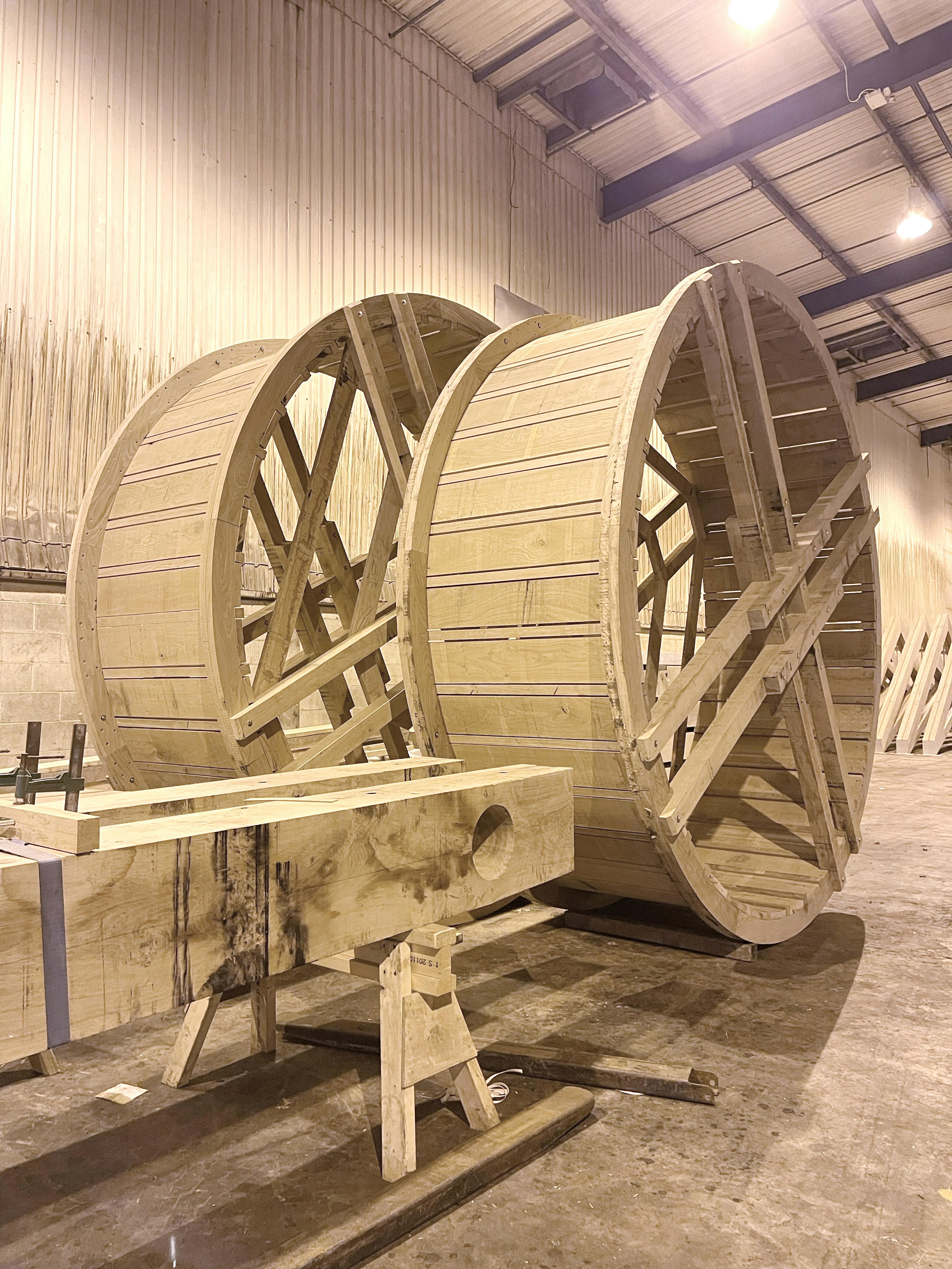 The two wheels of a full scale working oak and ash trebuchet during manufacturing in a workshop
