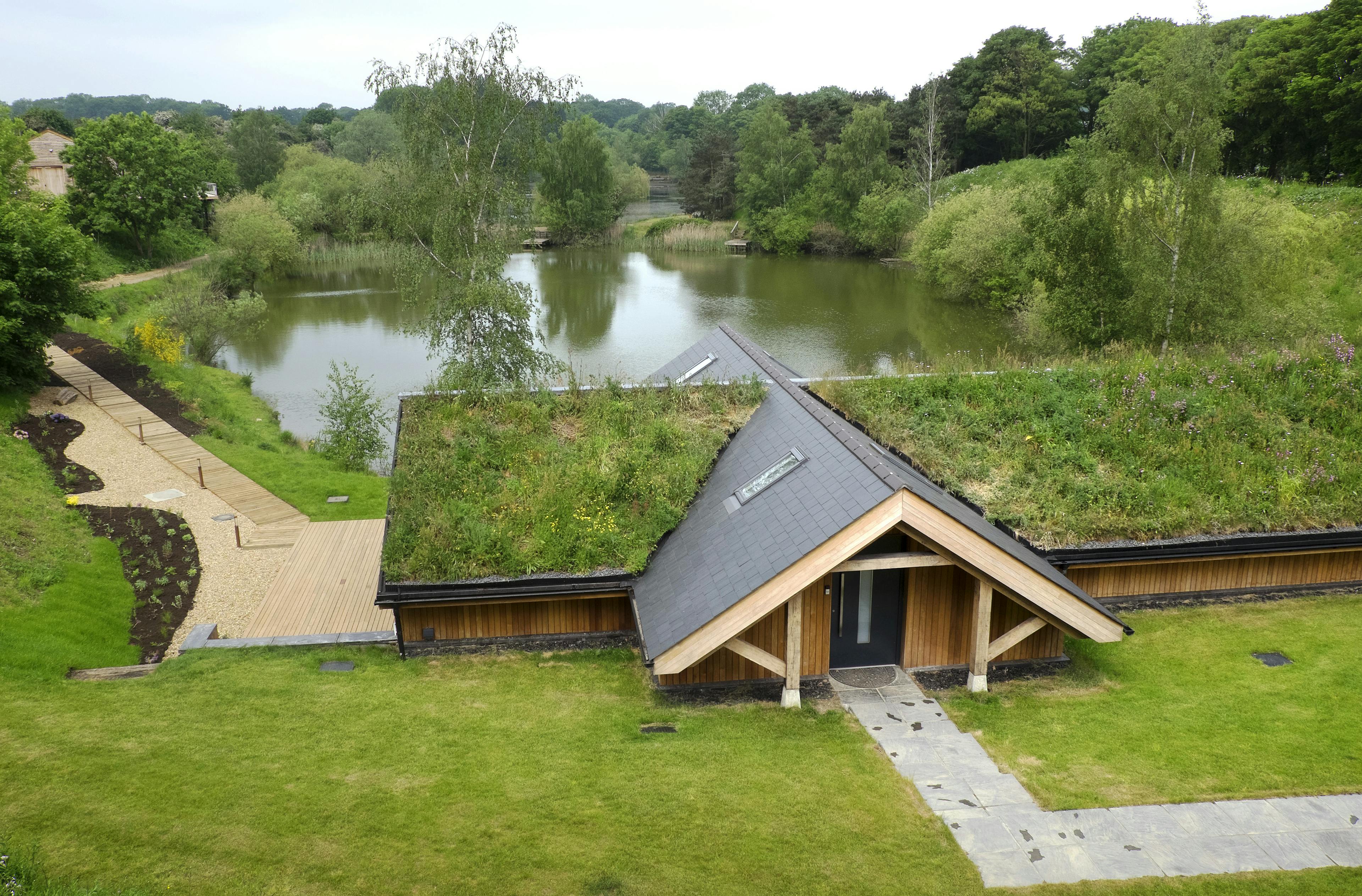 Green roof atop a contemporary oak-framed bungalow, overlooking scenic lakes