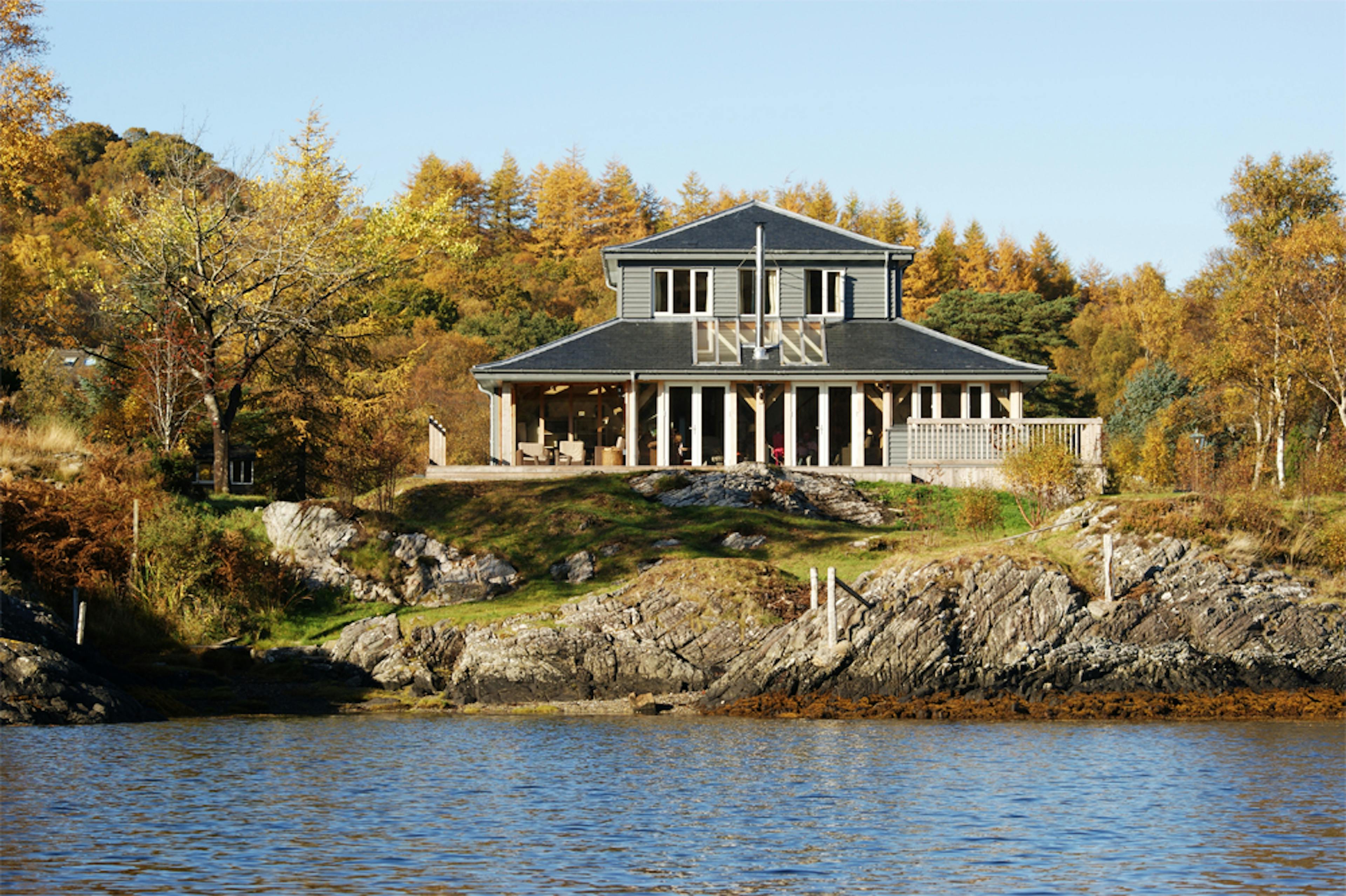 External view of an oak-frame self-build guest house nestled beside a loch