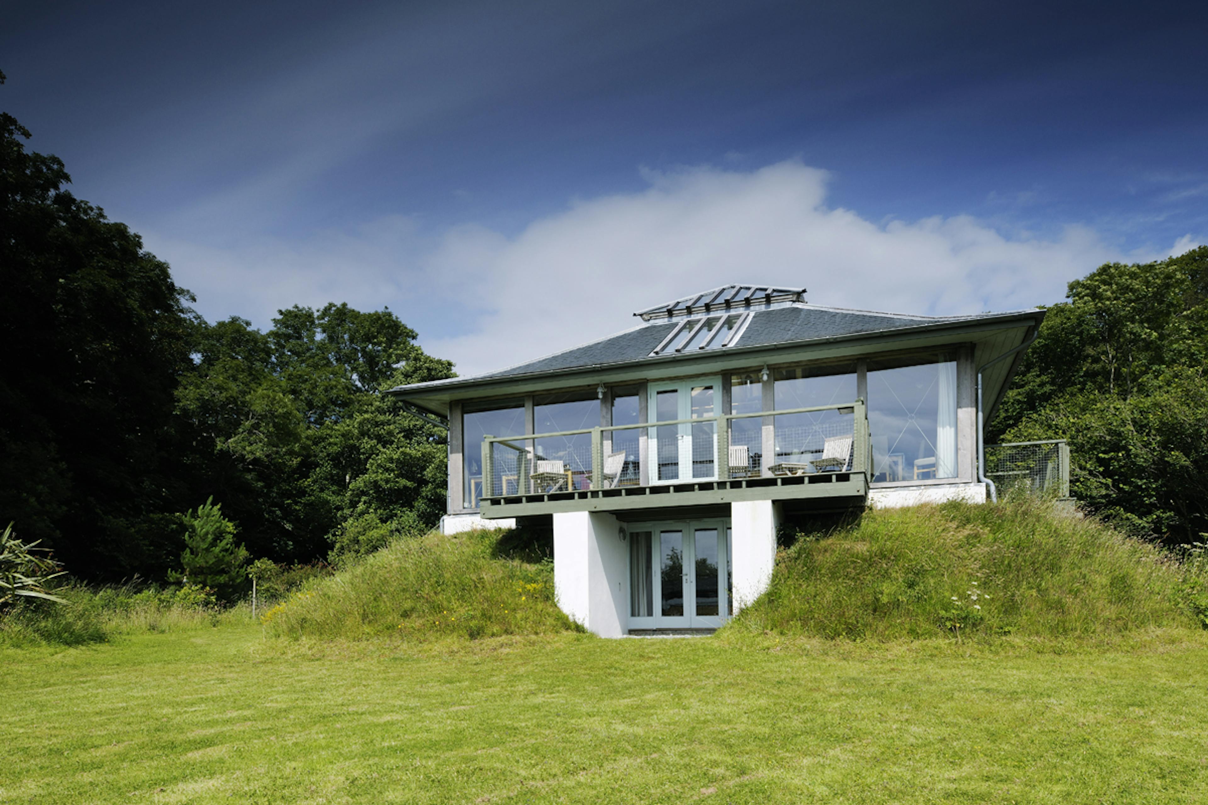 Exterior view of a two-story oak-framed reverse-level home offering panoramic coastal views