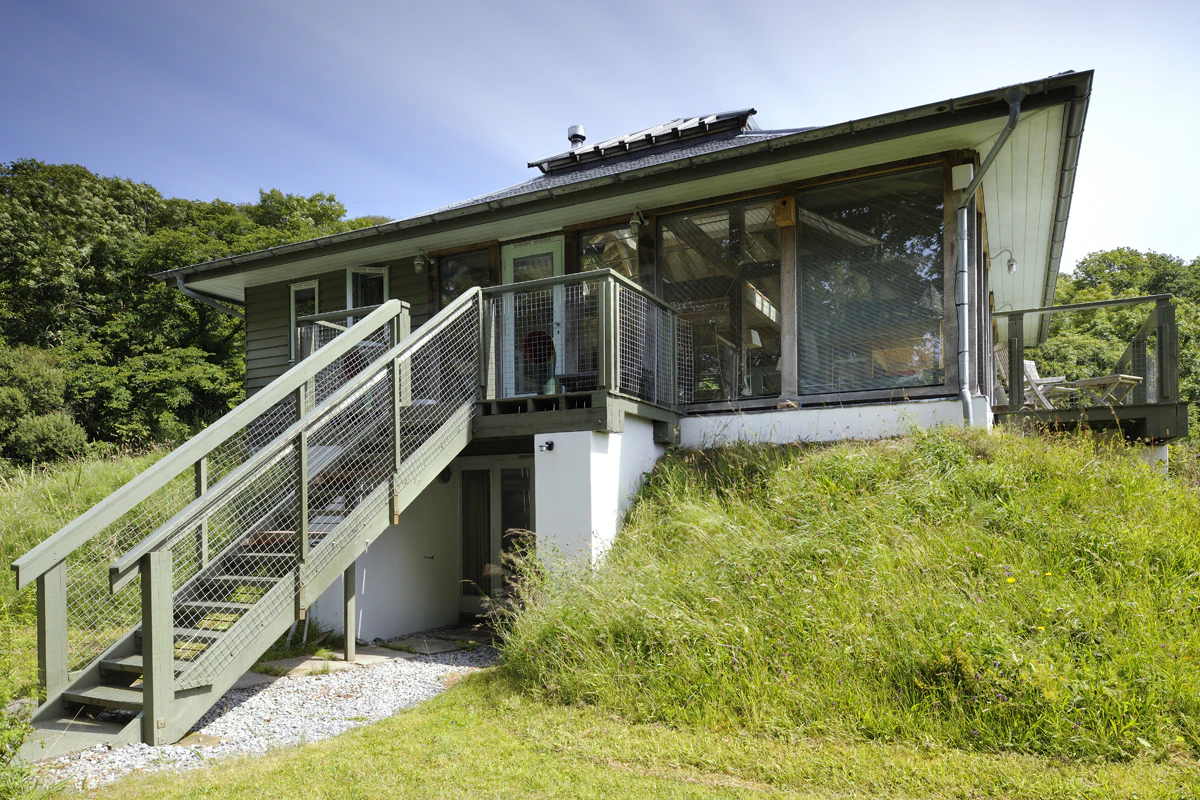 Exterior view of a two-story reverse-level home situated by a loch