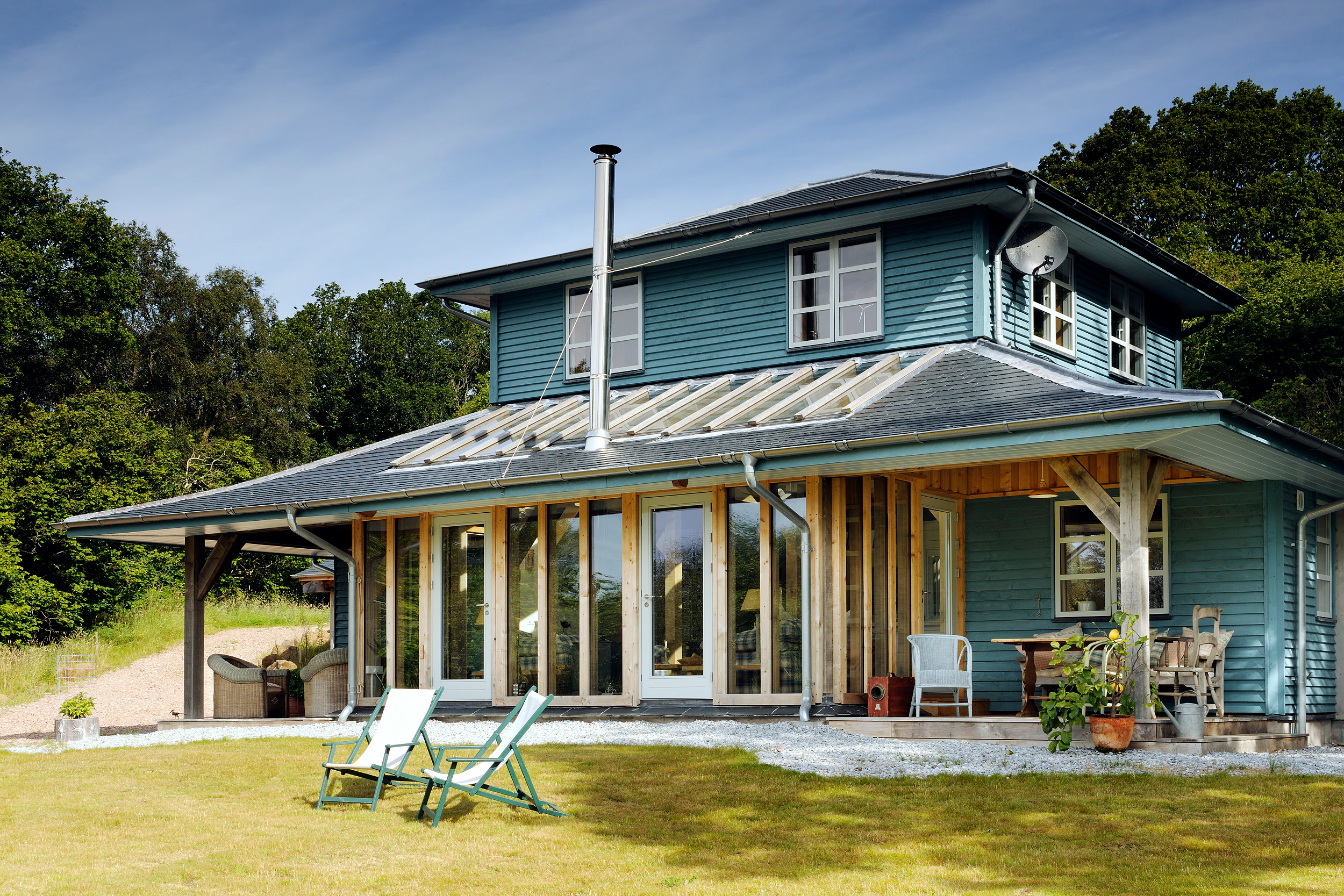 A blue painted timber clad oak framed home with a veranda