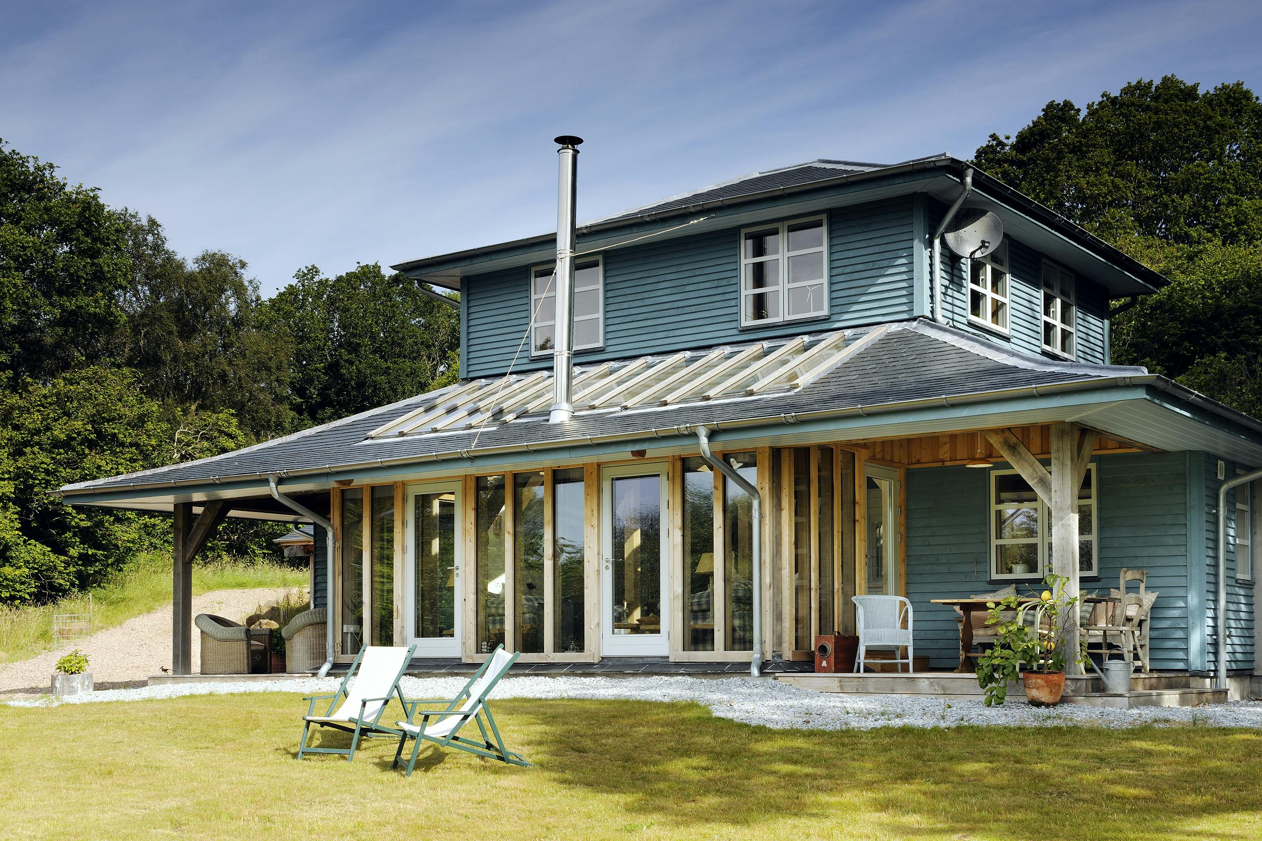 A blue painted timber clad oak framed home with a veranda