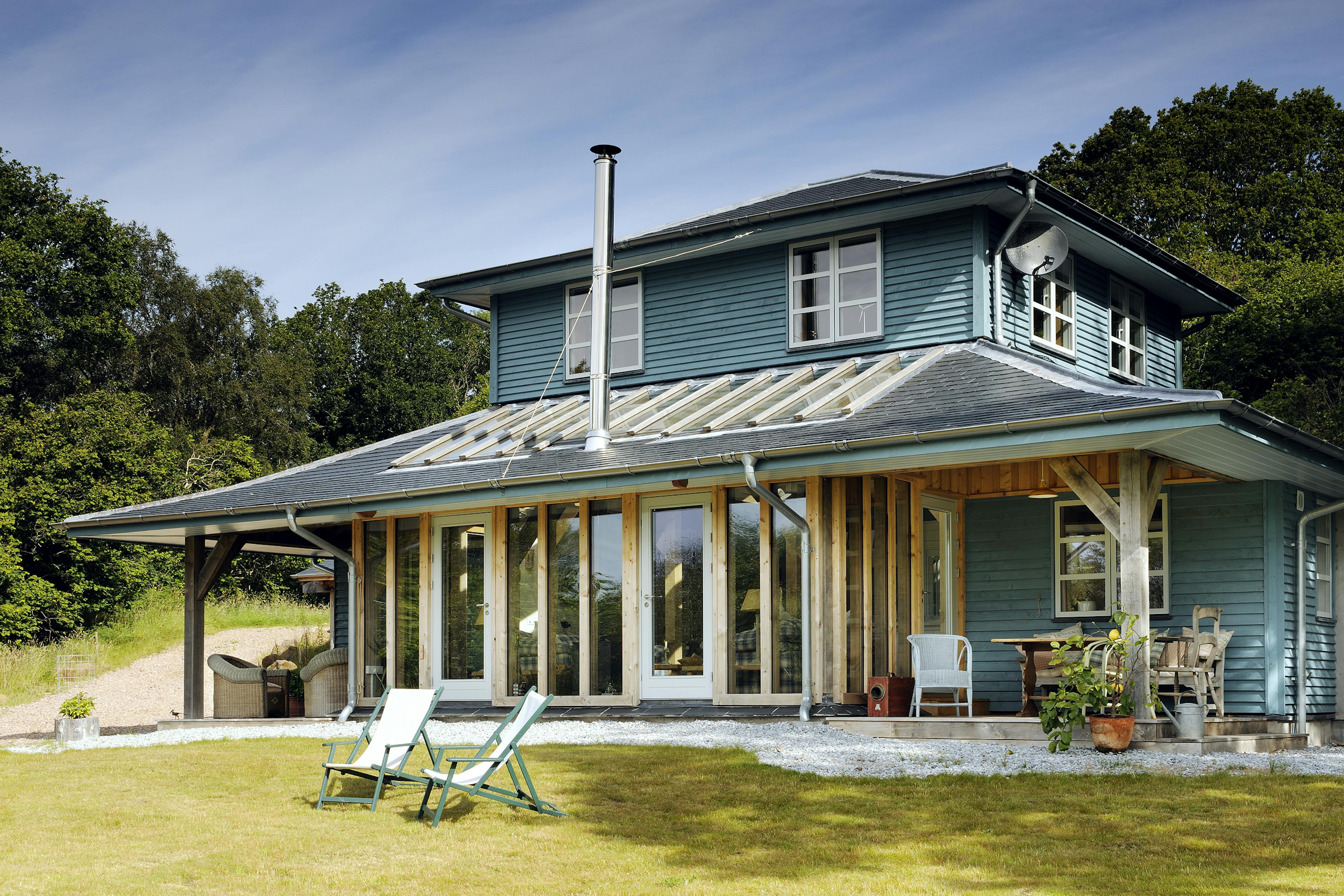 A blue painted timber clad oak framed home with a veranda