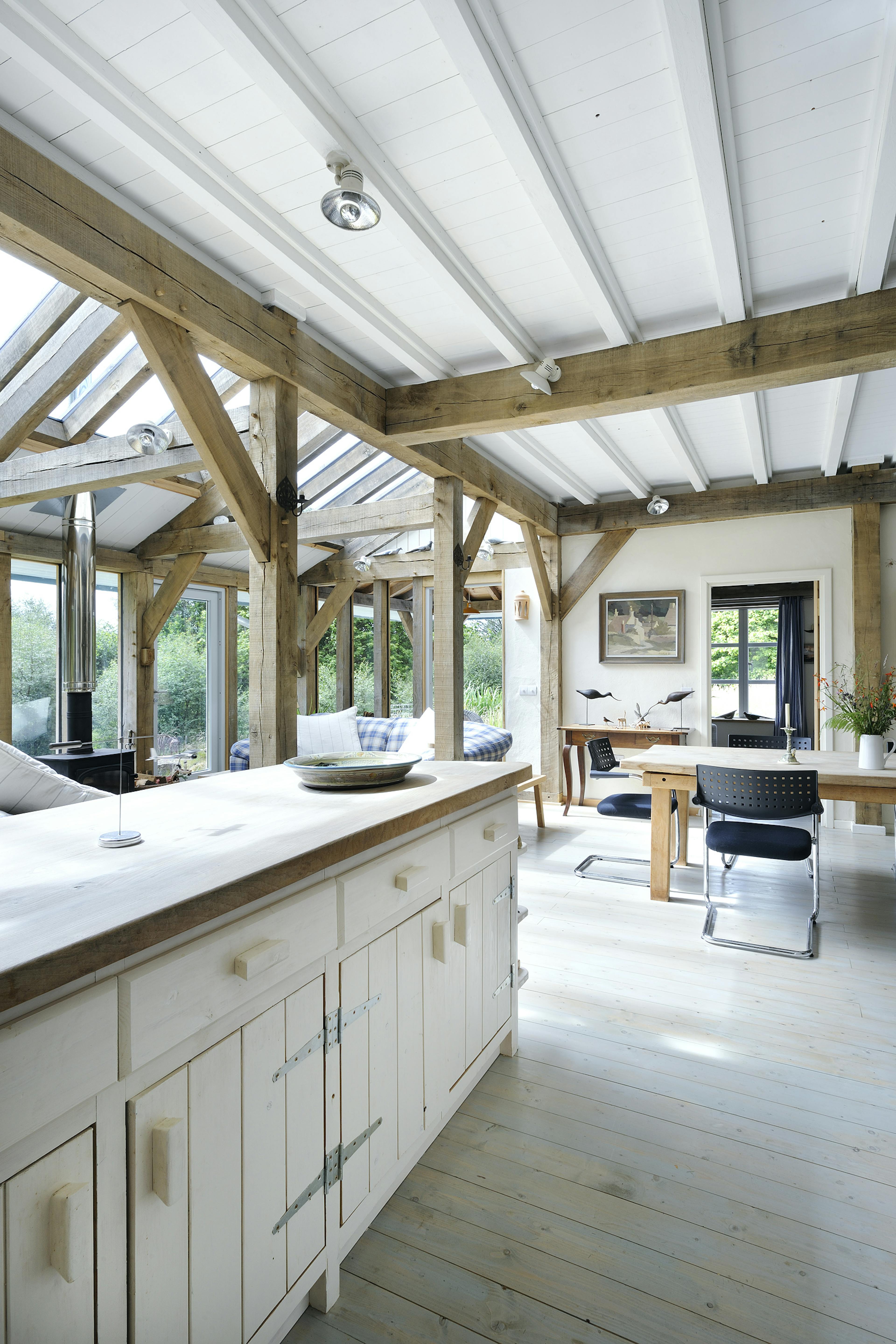 Interior view of an open-plan, oak-framed farmhouse-style kitchen