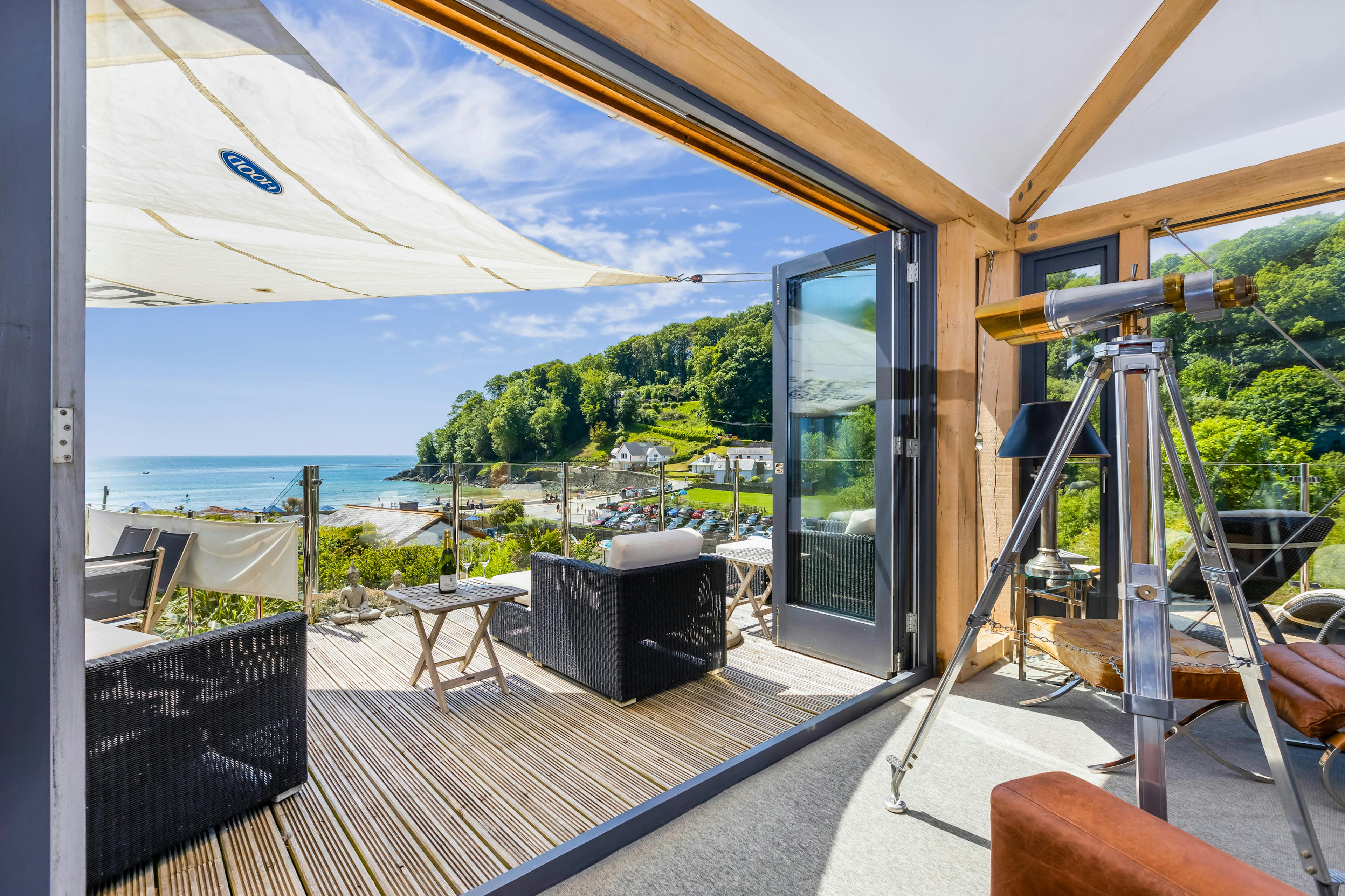An oak framed sitting room with a balcony and sea views