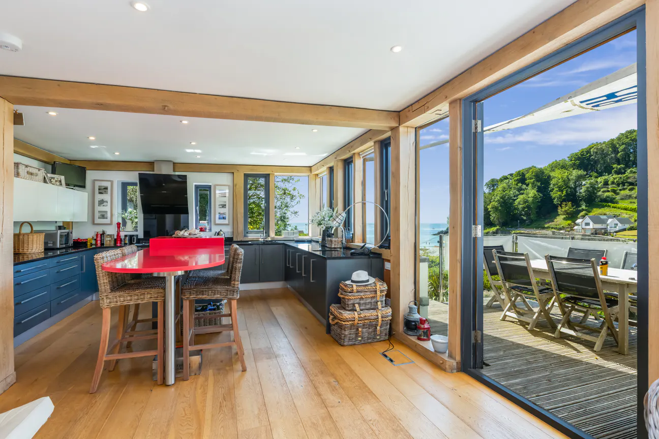 An oak framed modern kitchen with a balcony with outdoor tables and chairs