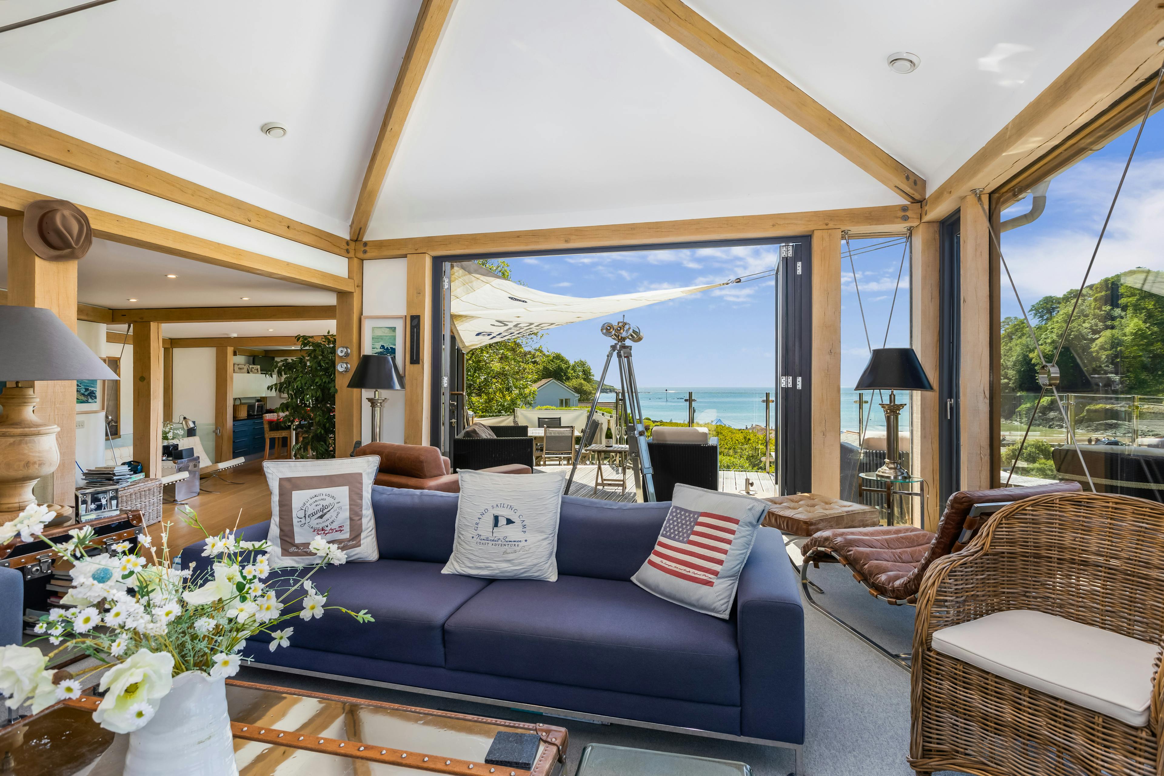 An oak framed sitting room with a balcony and sea views