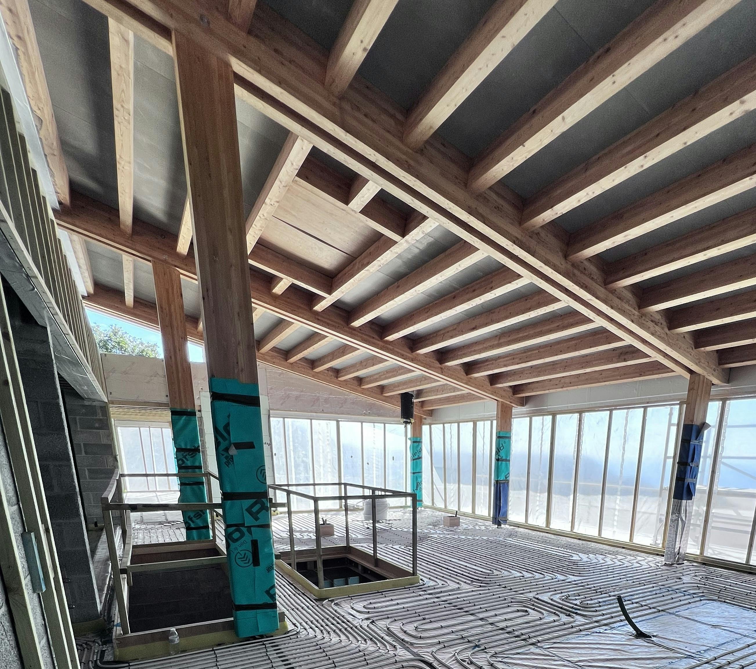 A glulam mono pitch roof during construction with the post wrapped