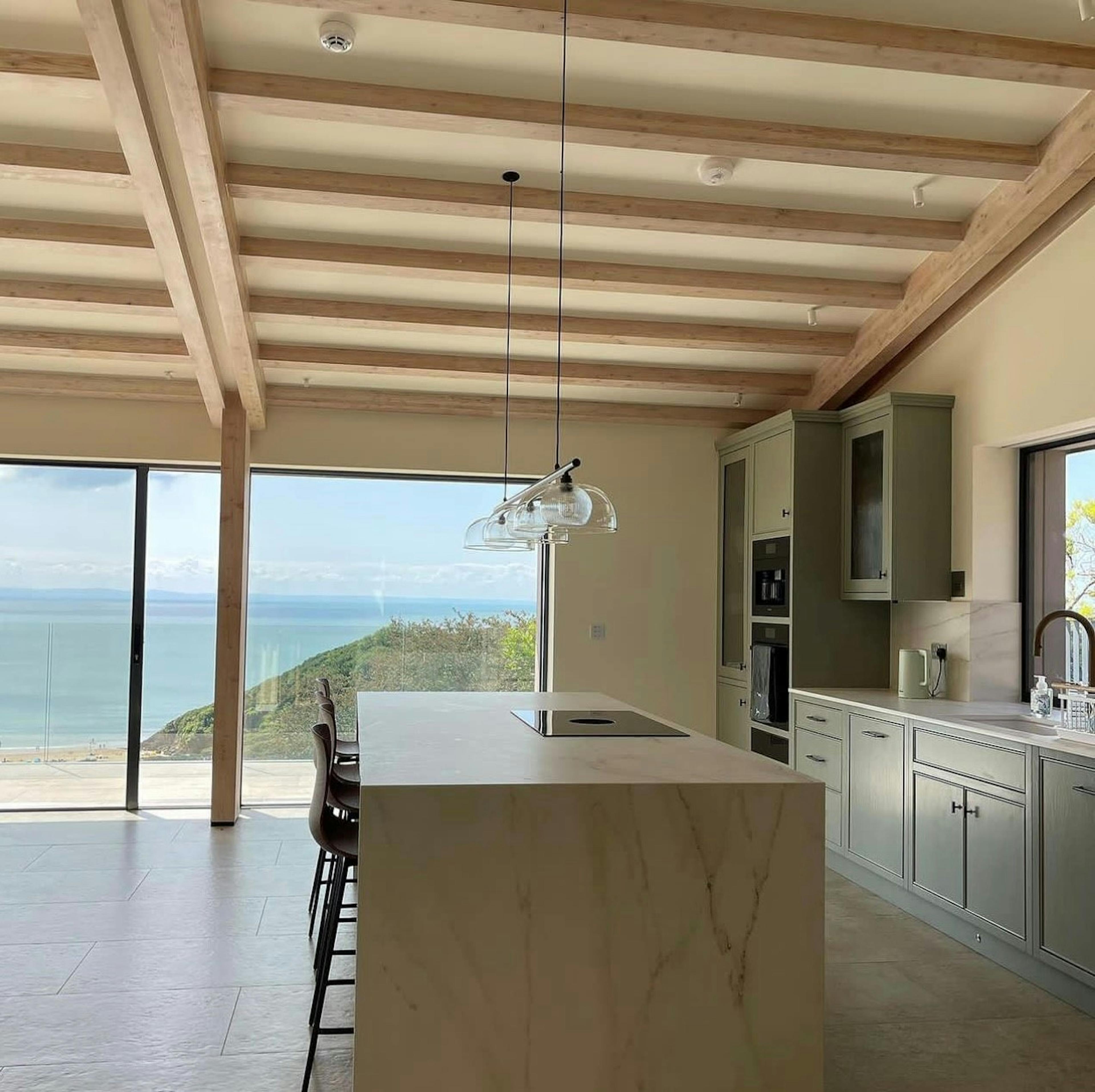 Oak glulam mono pitch roof for an open plan living room and kitchen extension with sea views