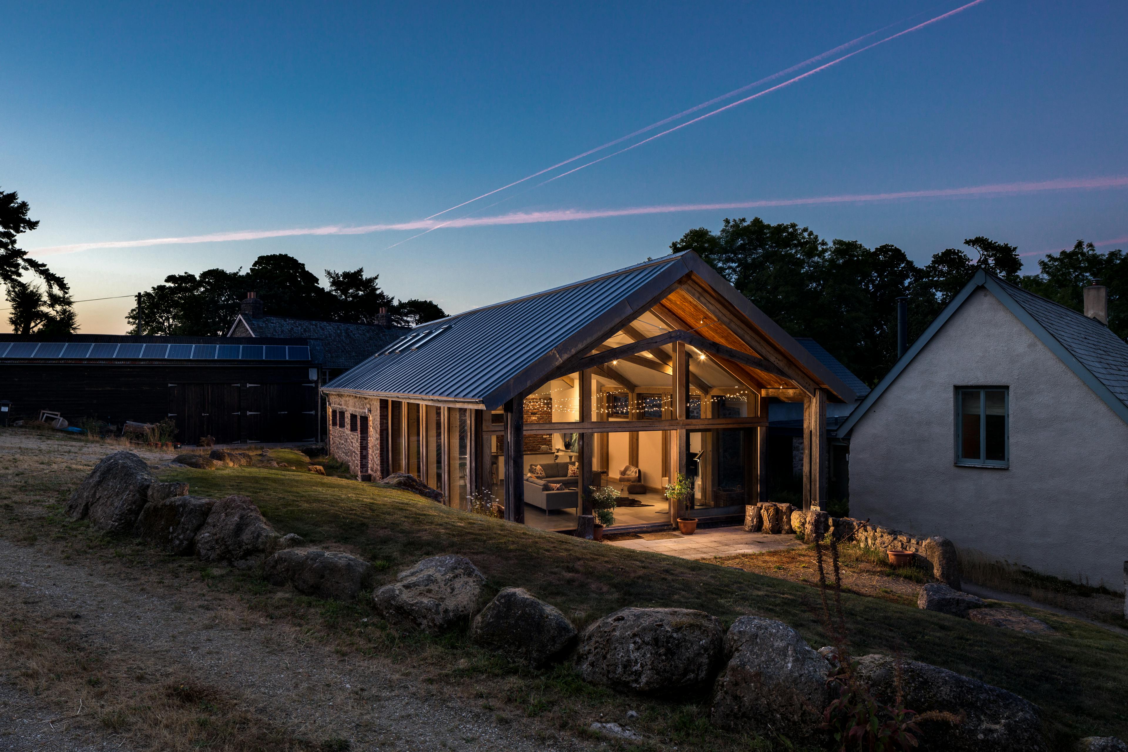 Exterior view of a contemporary annexe with a structural oak frame, set in a countryside landscape