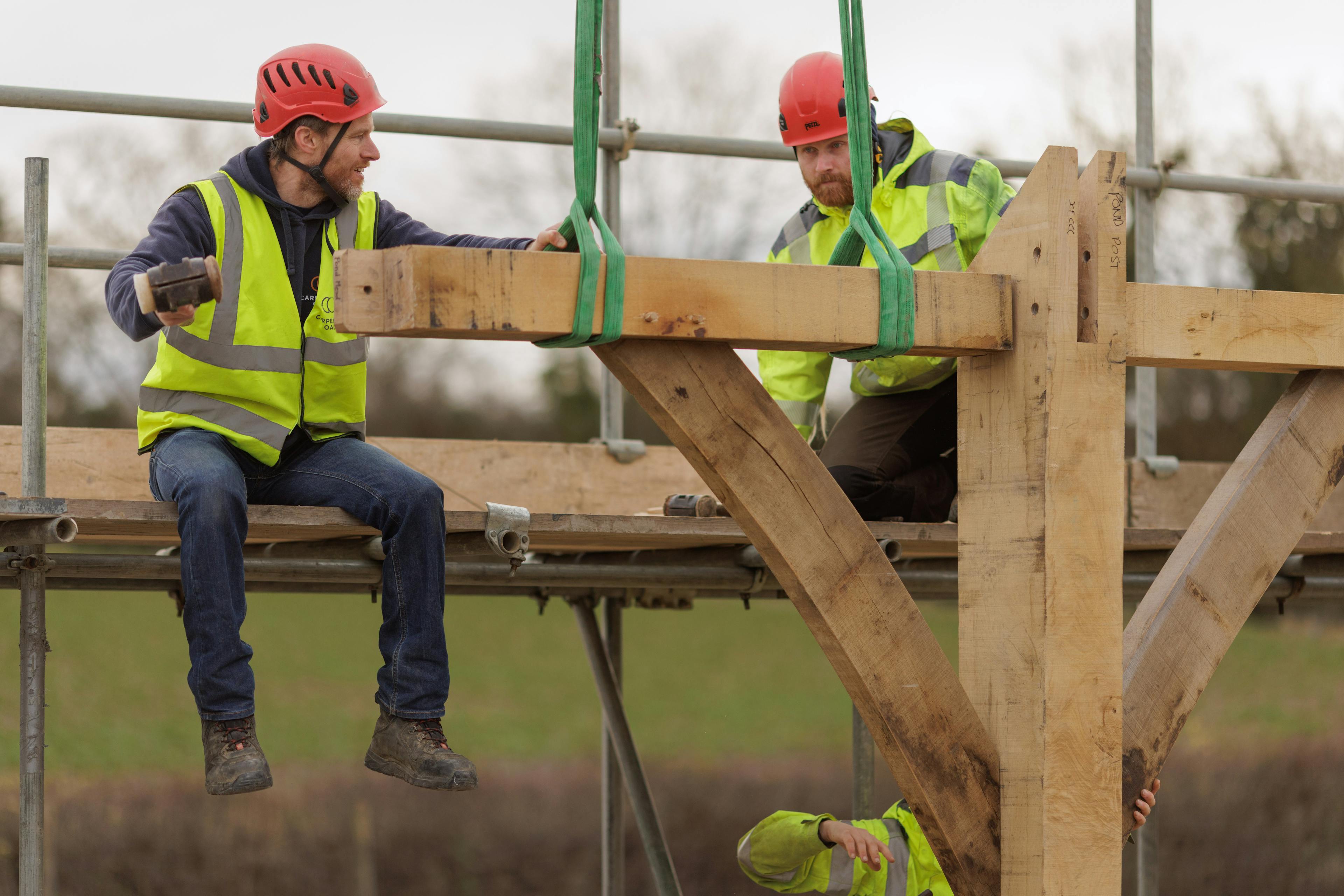 Two carpenters installing an oak frame