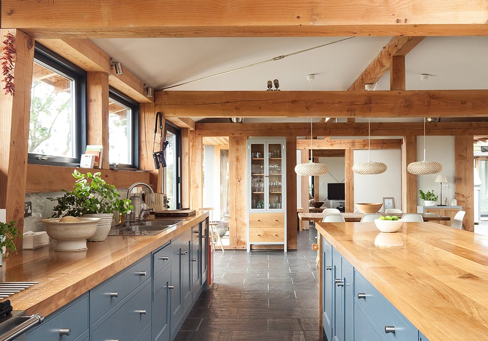 A kitchen with blue cabinets in a Douglas fir framed farmhouse home