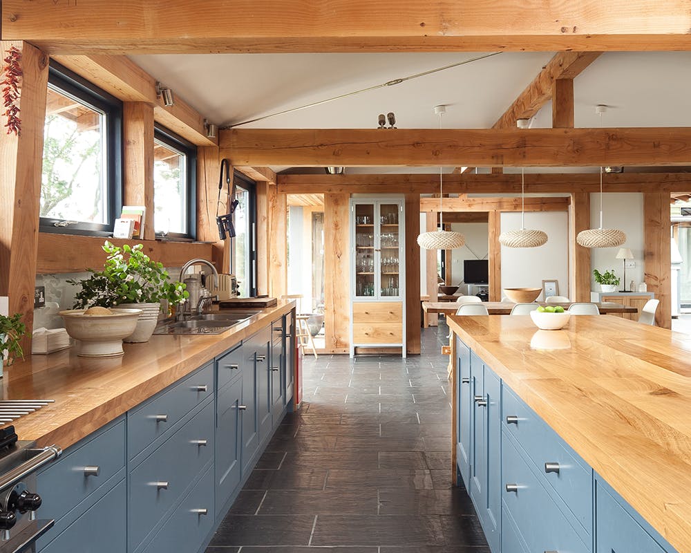 A kitchen with blue cabinets in a Douglas fir framed farmhouse home