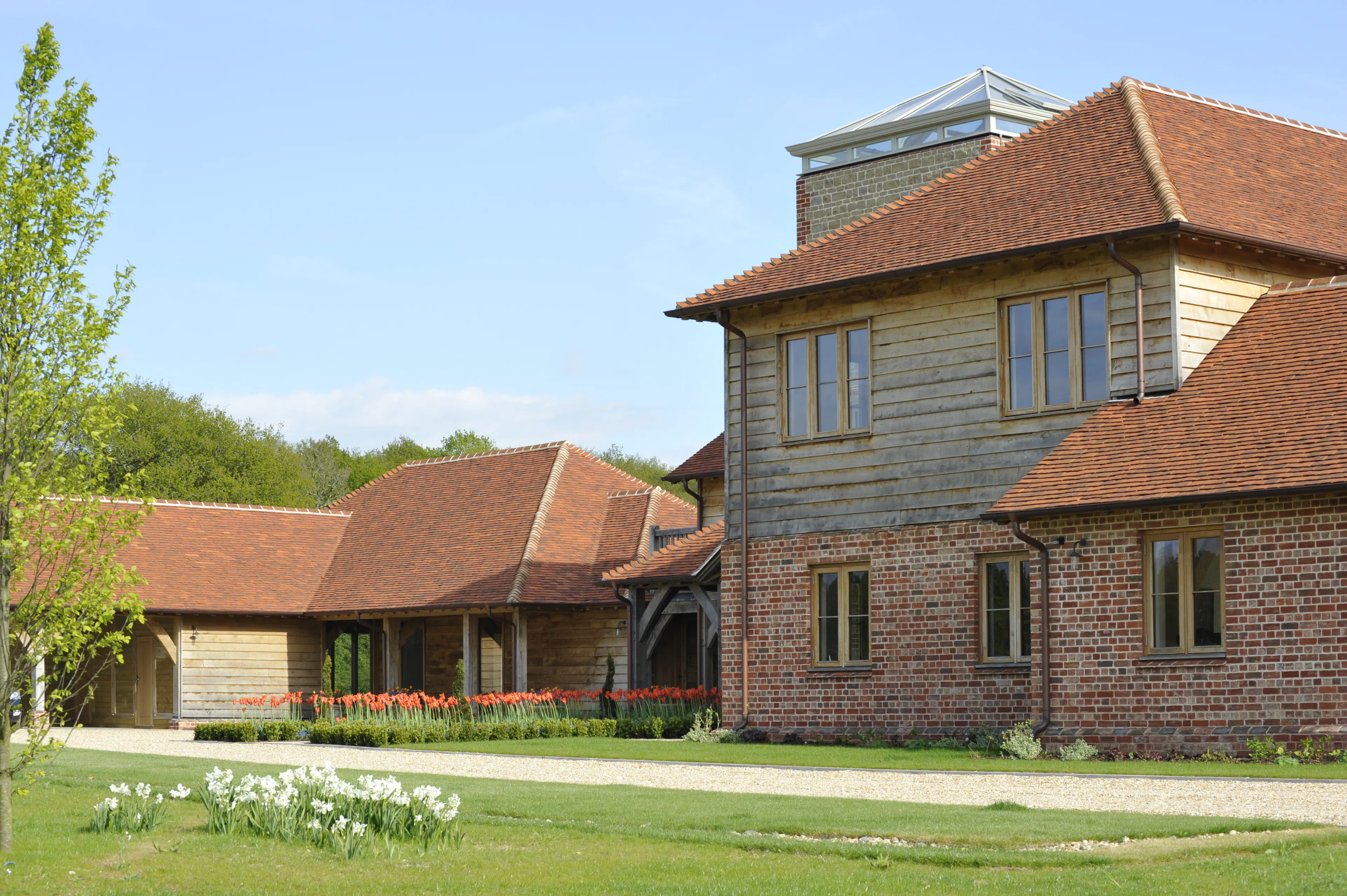 A large-scale timber-framed family home featuring a three-story, fully glazed viewing tower
