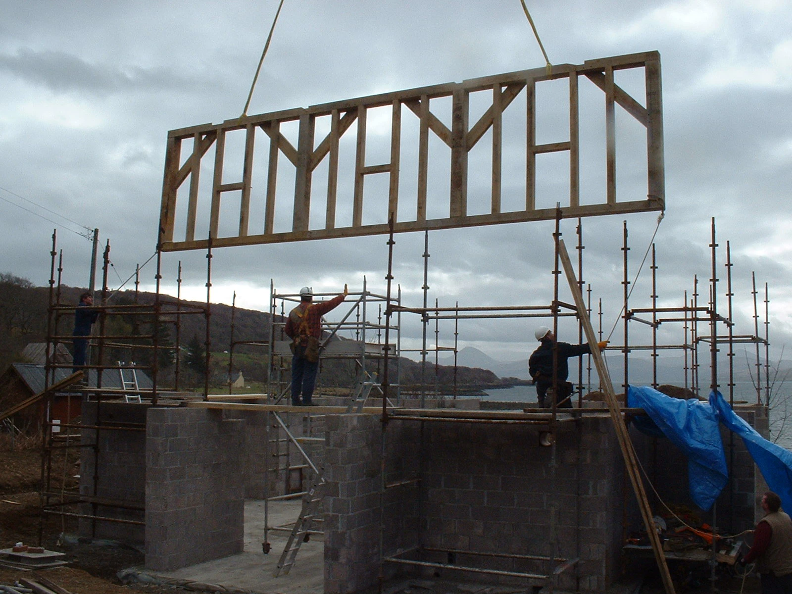 Lifting a preassembled wall section into place for a two-story oak-framed home
