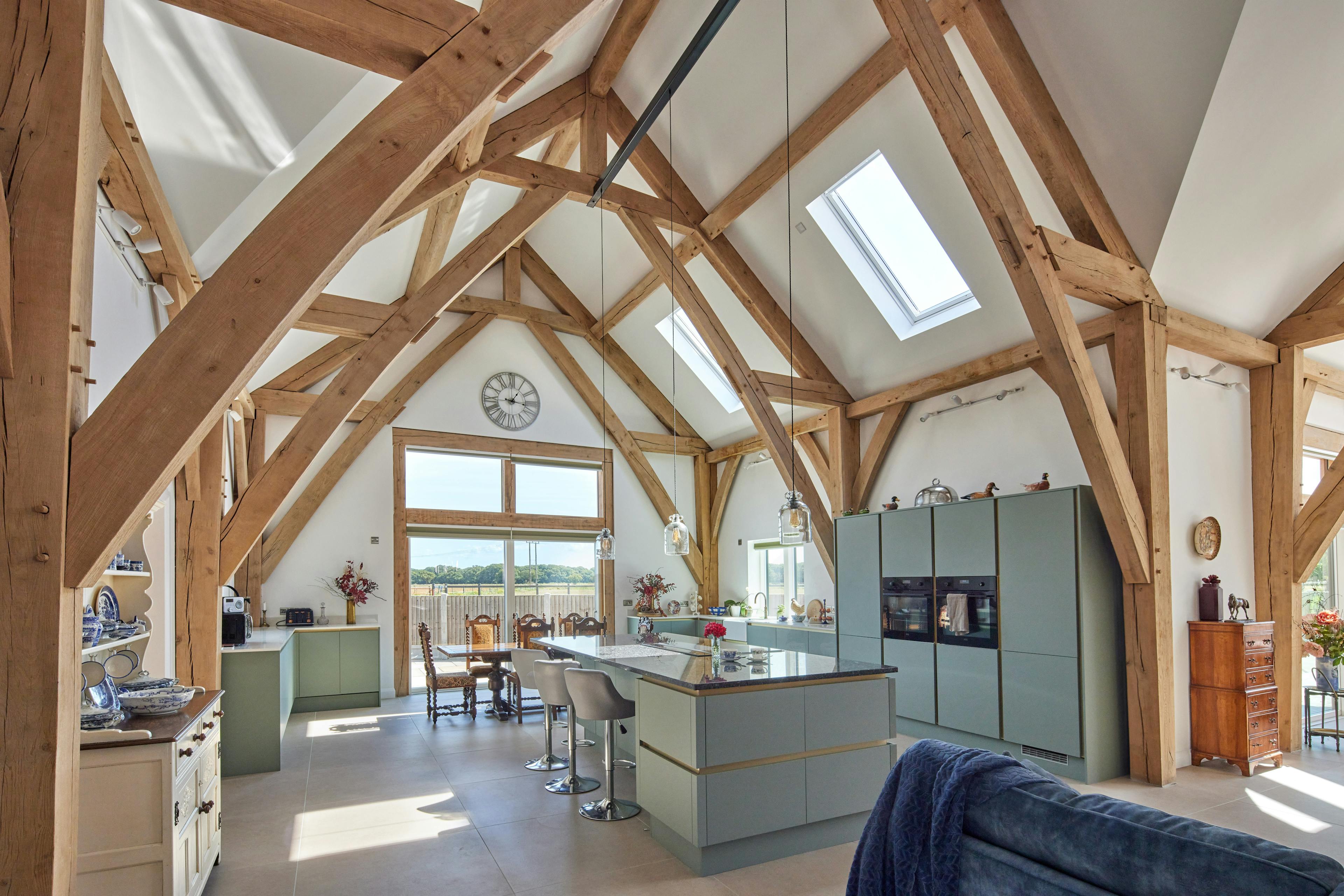 A open plan living room and kitchen with a vaulted oak frame