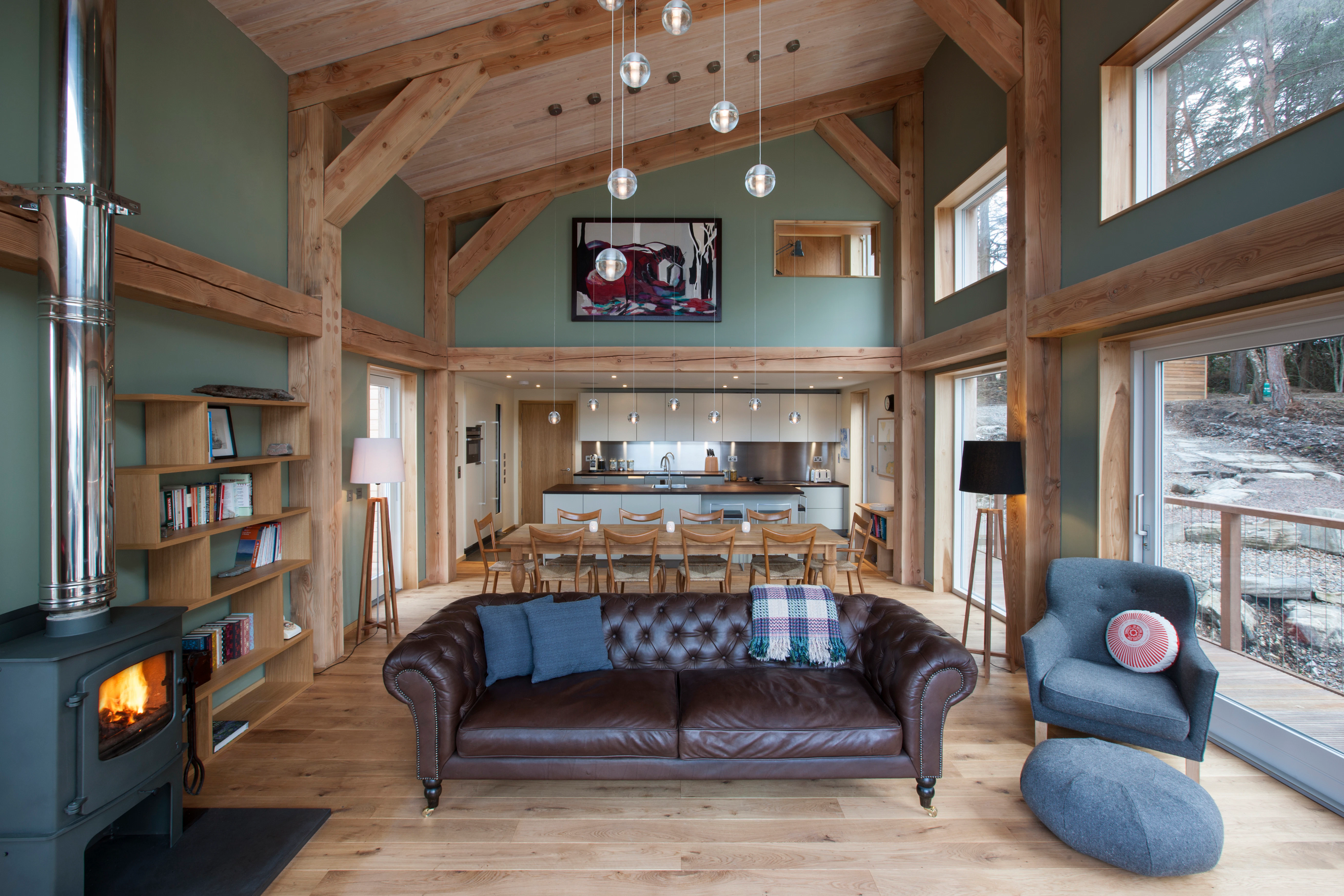 Interior view of an open-plan living space with a Douglas fir frame and a cosy fireplace