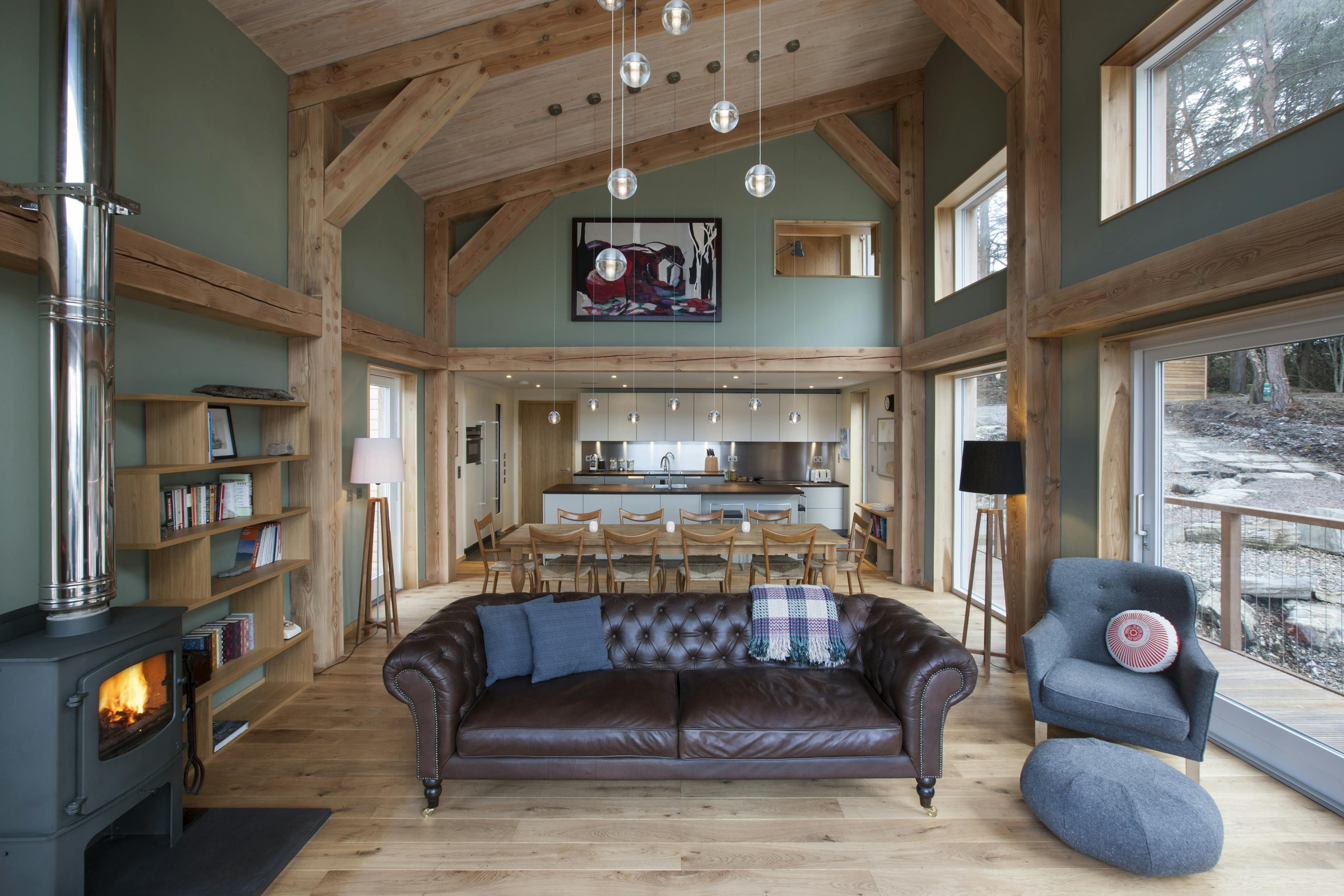 Interior view of an open-plan living space with a Douglas fir frame and a cosy fireplace