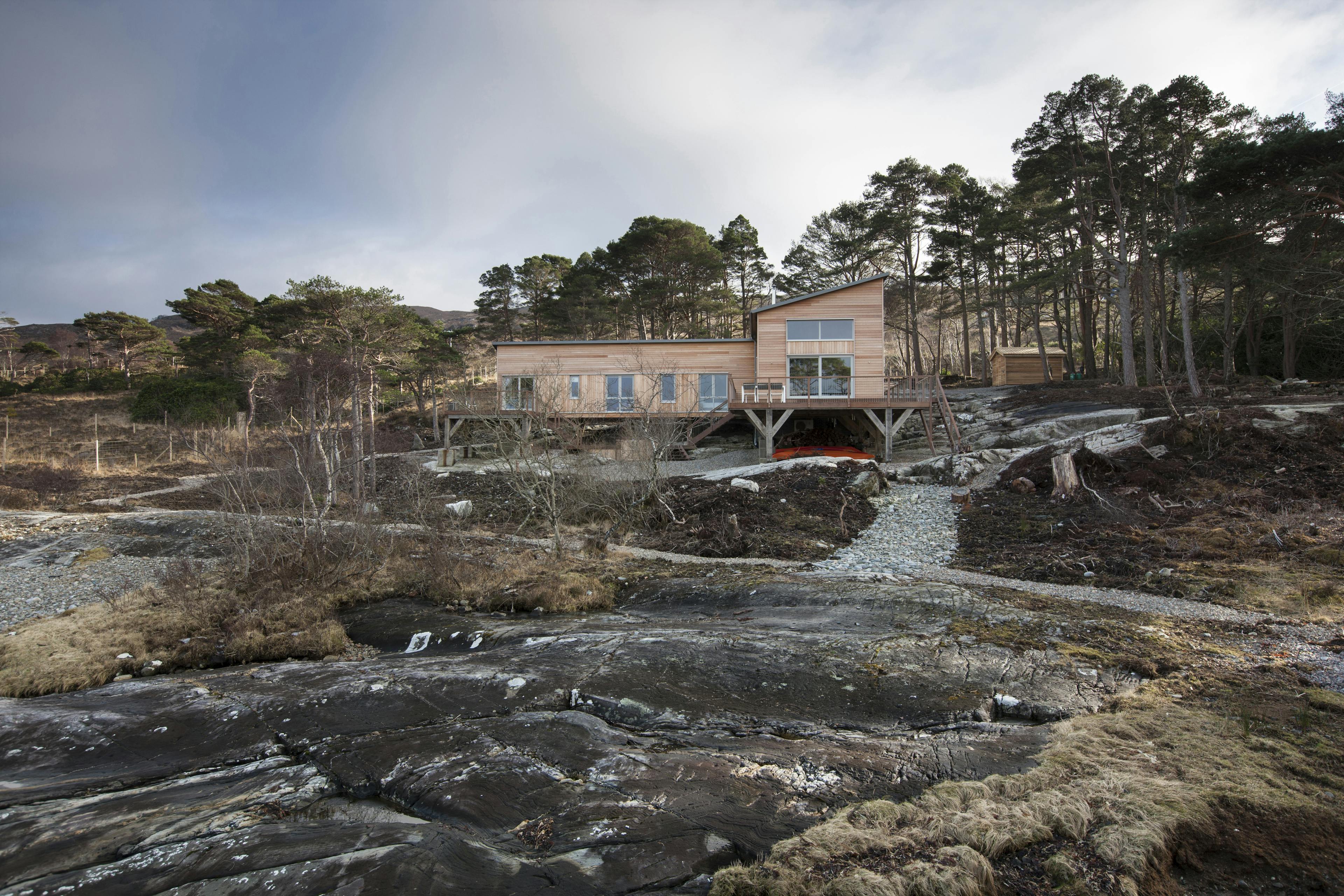 Exterior view of a Douglas fir-framed home situated on the shore of a loch