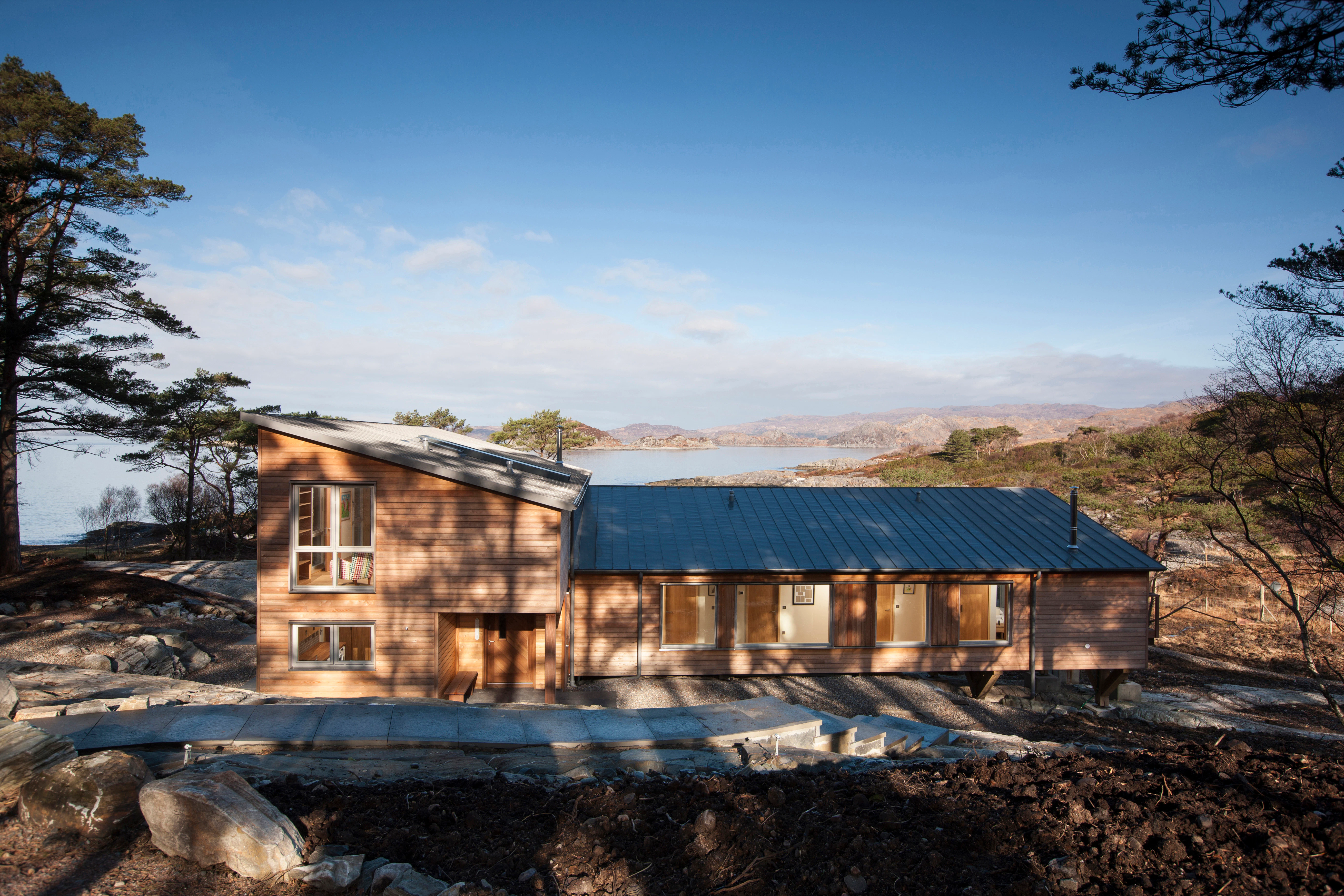 Rear view of a Douglas fir-framed family home with timber cladding for a rustic look