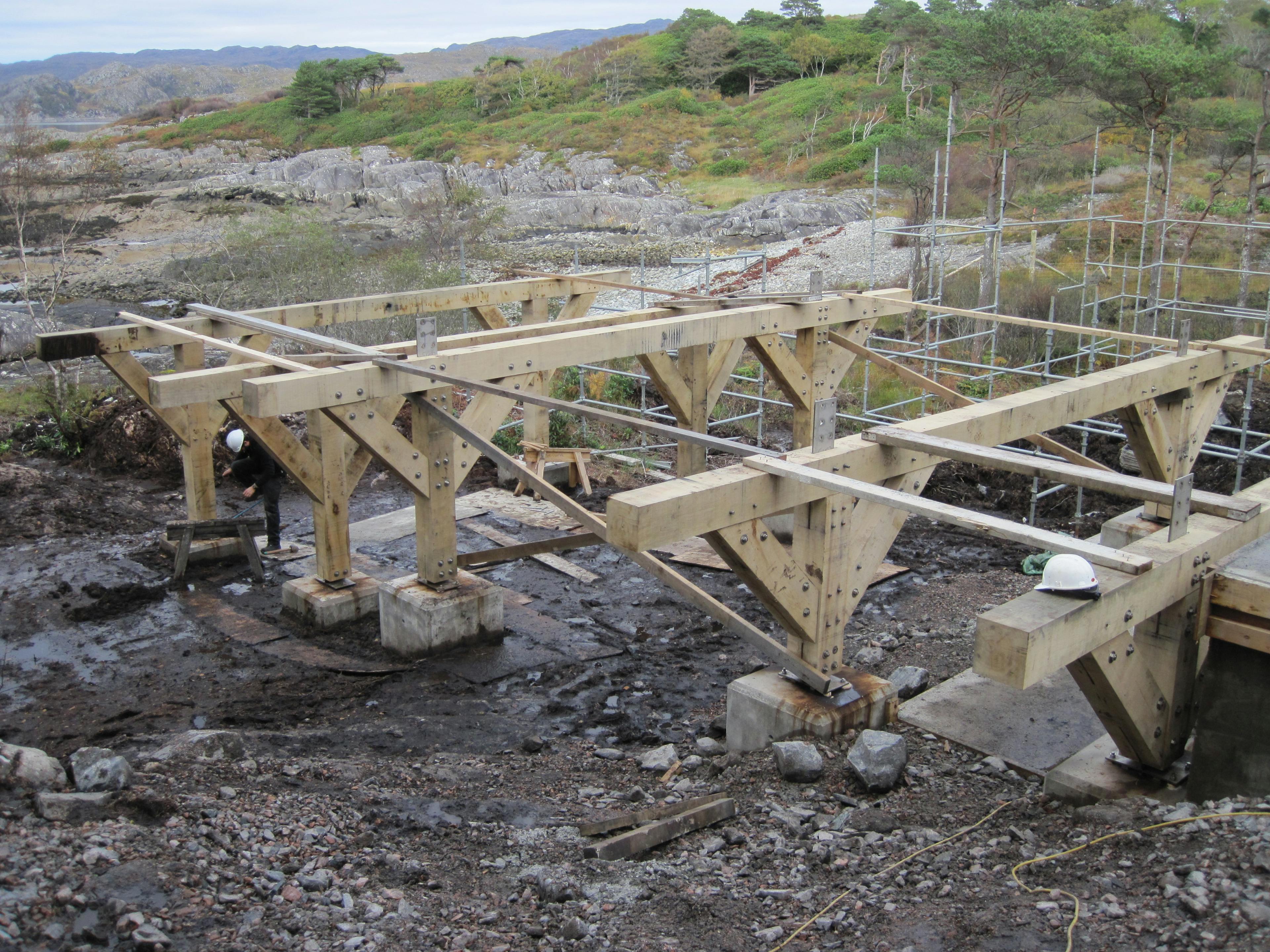 Assembling concrete plinths with oak-frame structures to support the ground floor deck for a Douglas fir-framed family home