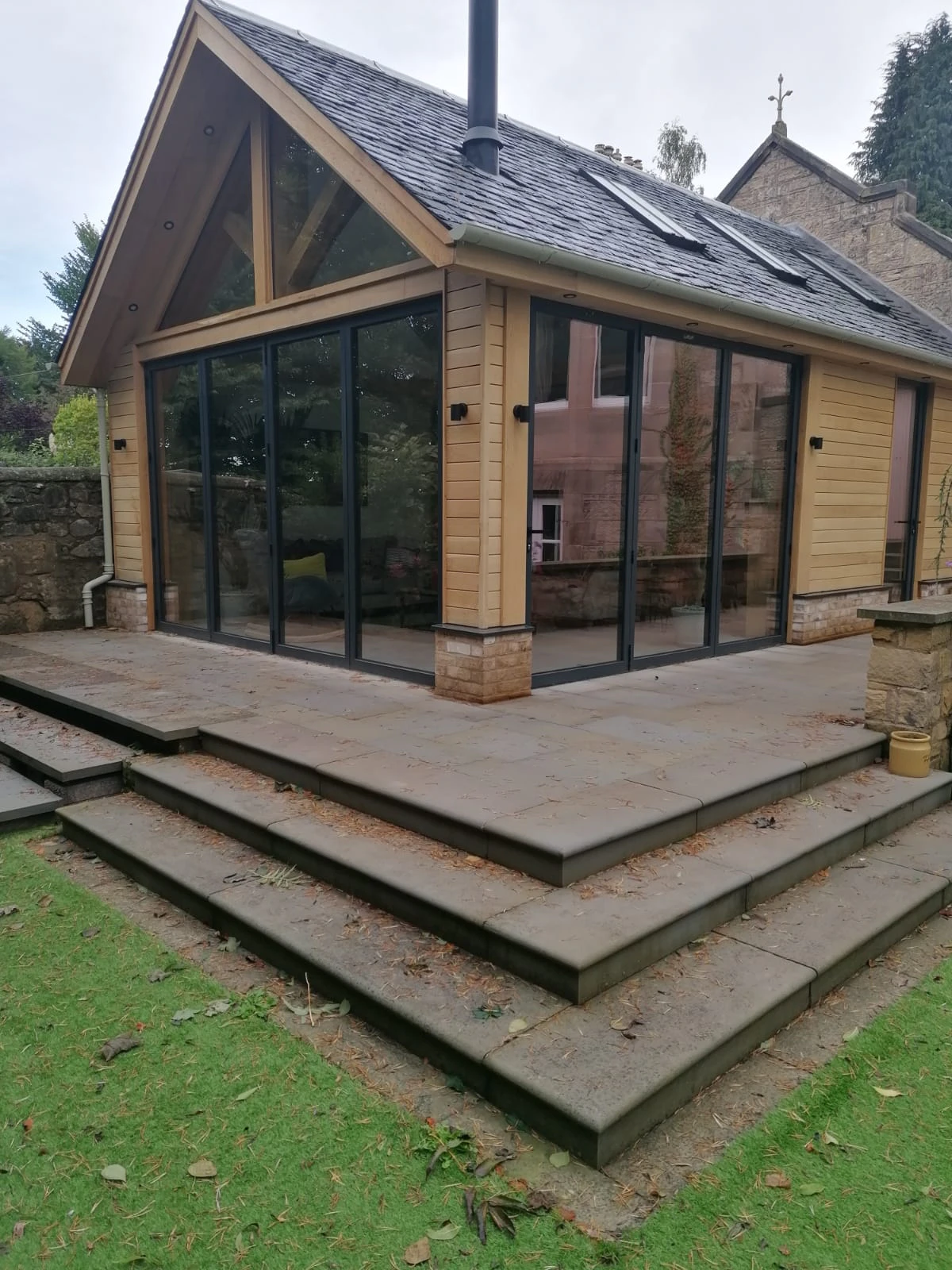 Oak-framed garden room with tiered patio steps and large expanses of glazing for maximum natural light