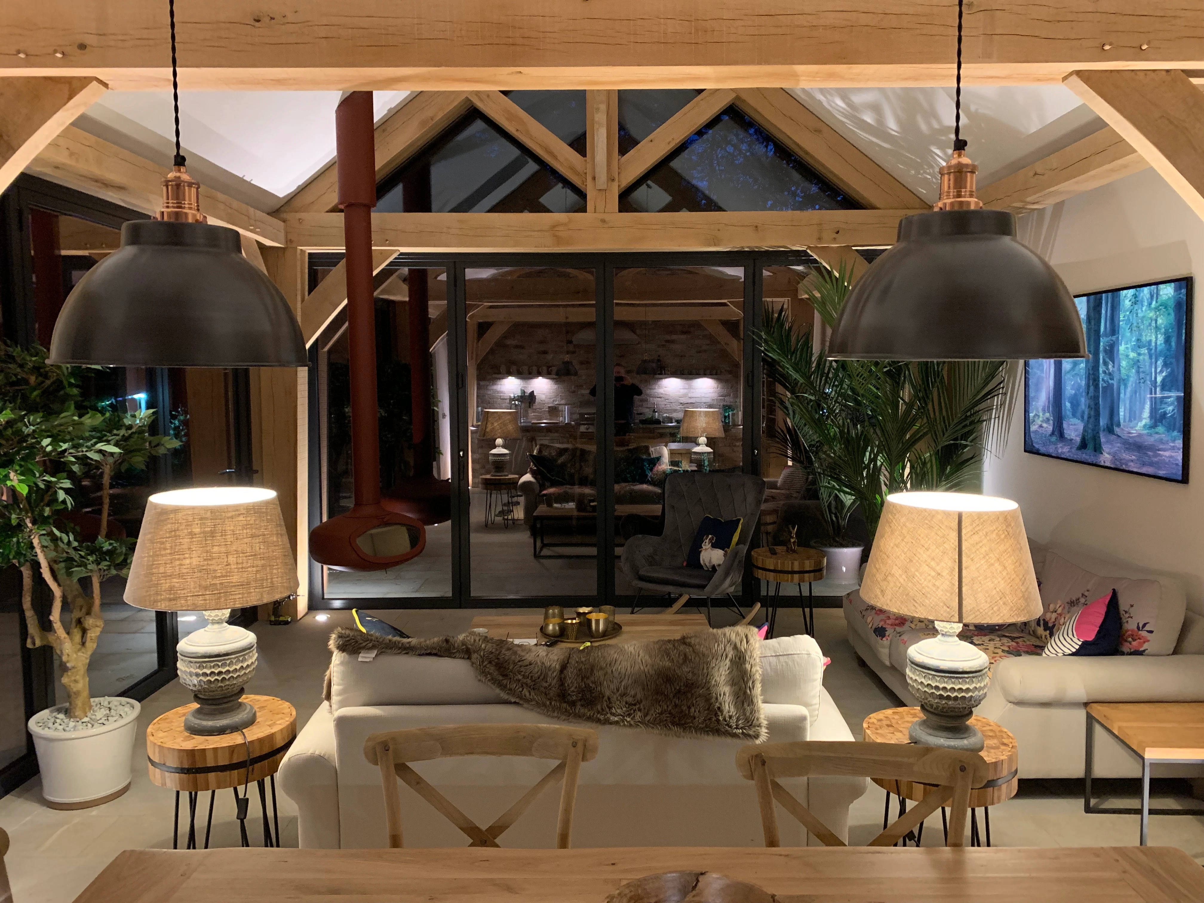 Interior view of an oak-framed garden room with a fully outfitted living space and a built-in, unique wood burner