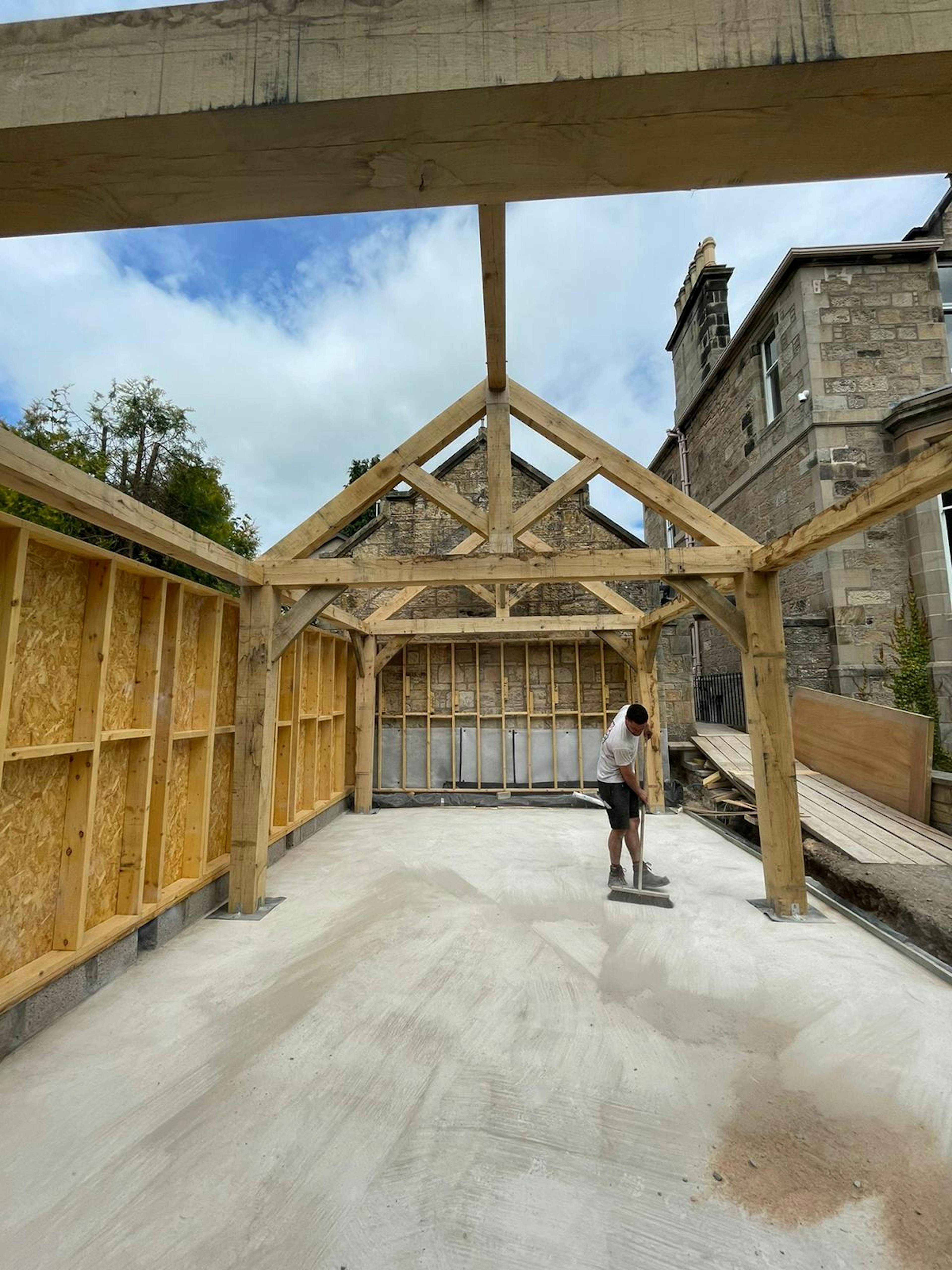 Site installation of an oak-framed garden room featuring traditional trusses