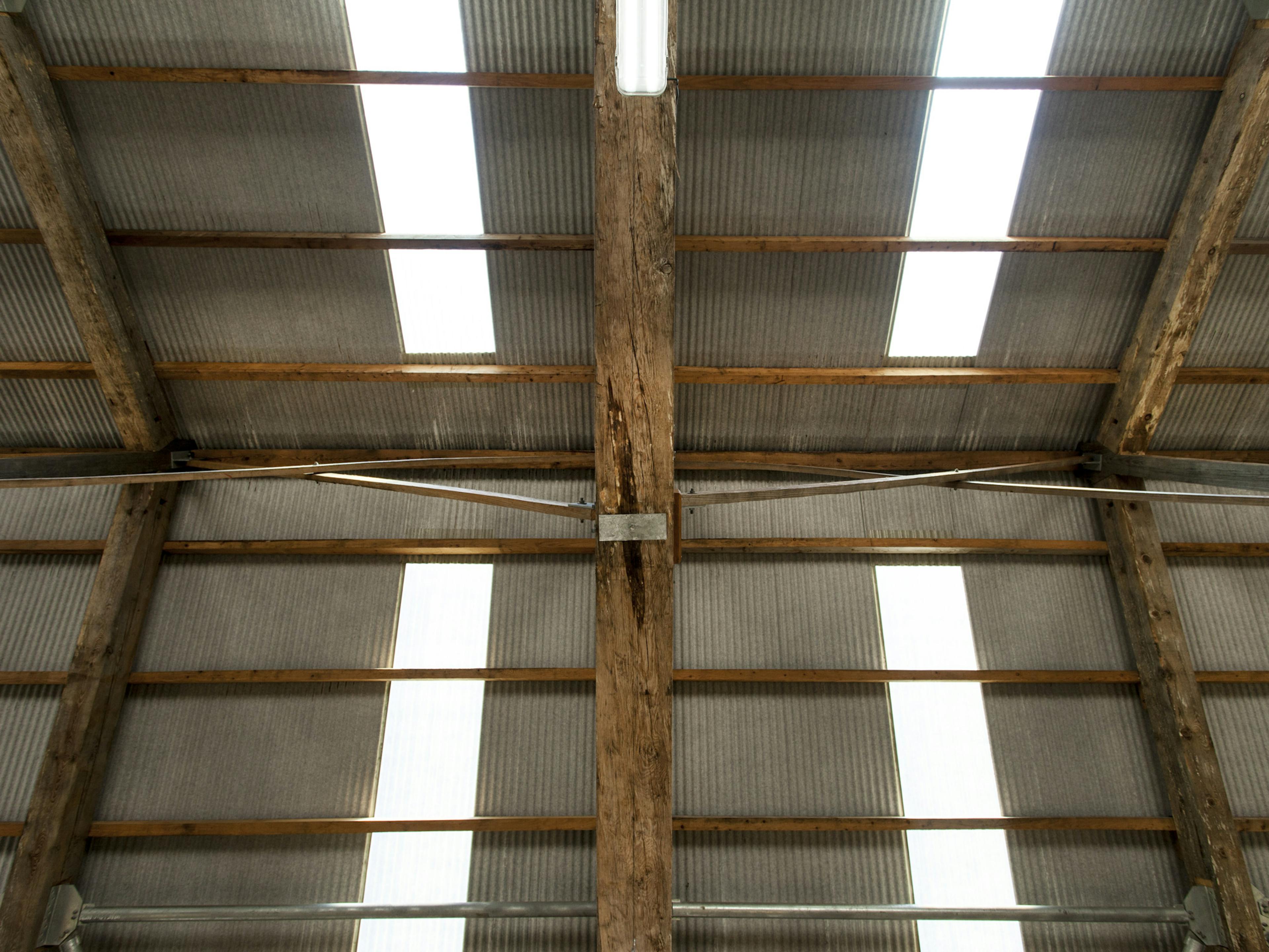 Interior view of a Douglas fir-framed tractor shed with a corrugated roof